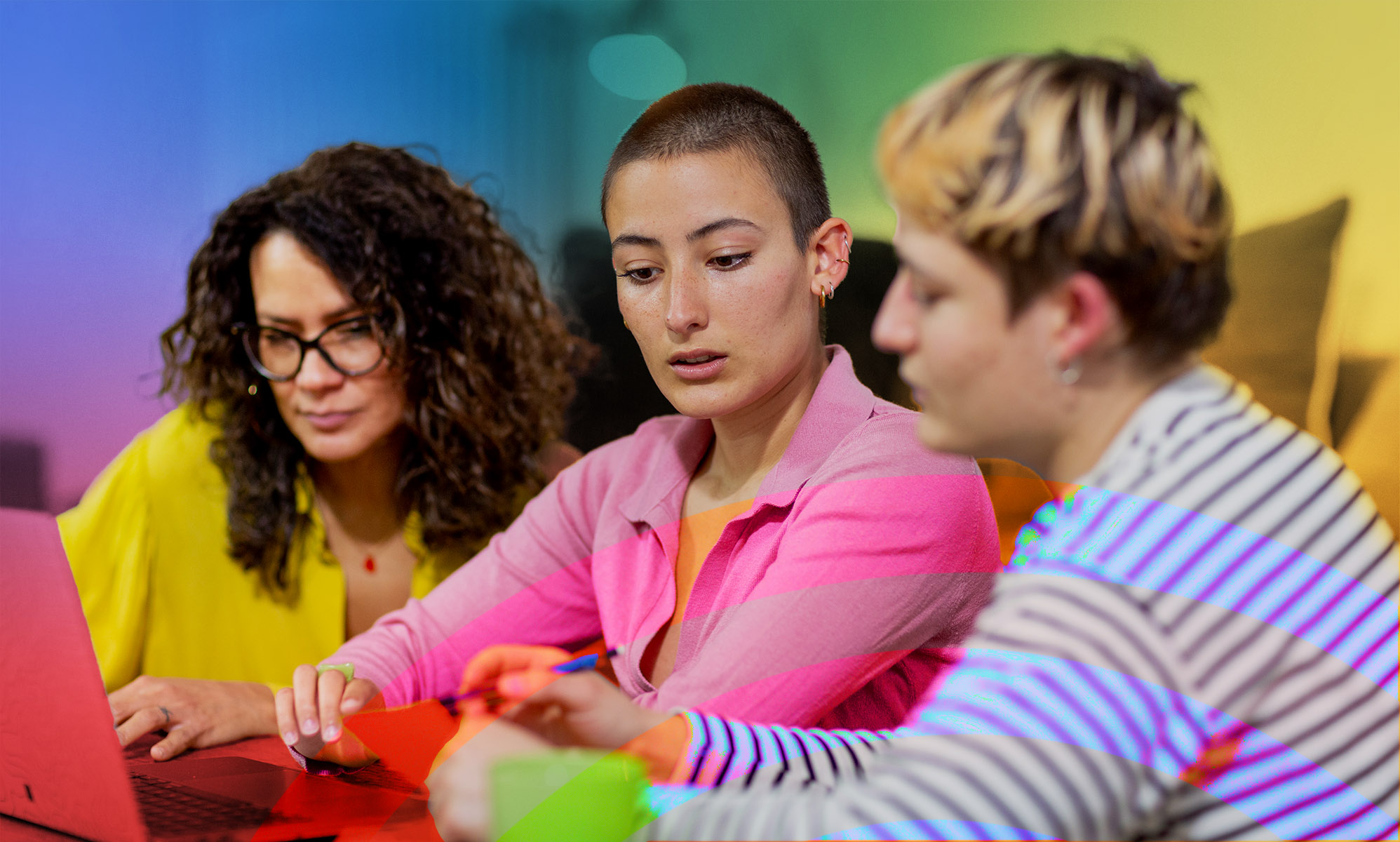 This is an image of 3 LGBTQ people working together. 