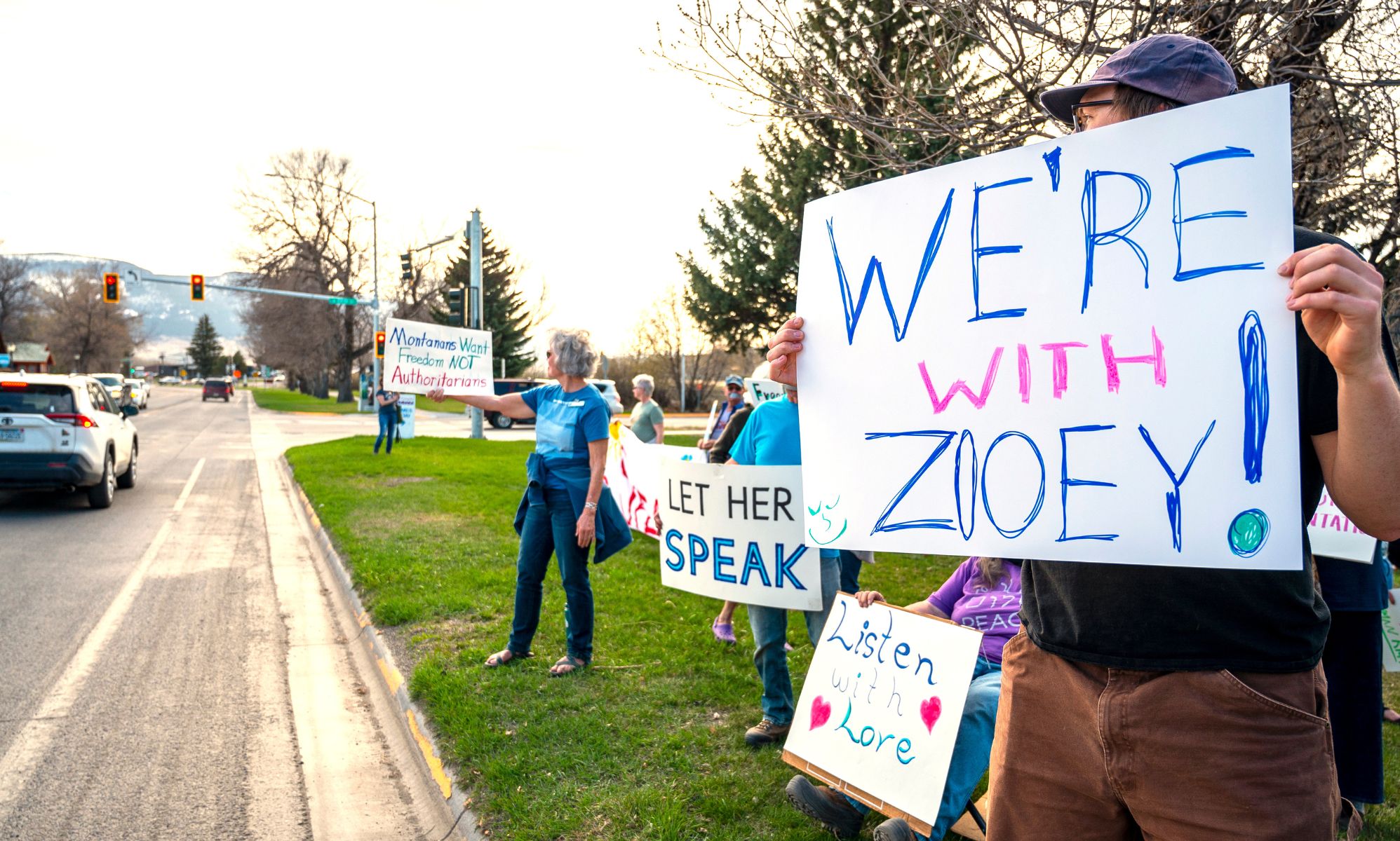 Protestors hold signs reading &quot;we