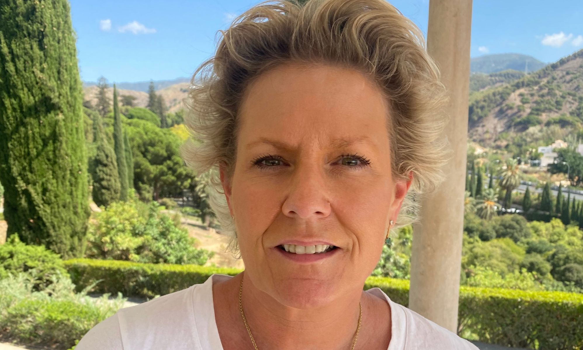 Doctor Helen Webberley, founder of online trans healthcare clinic GenderGP, wears a white shirt as she stands outside for a photo