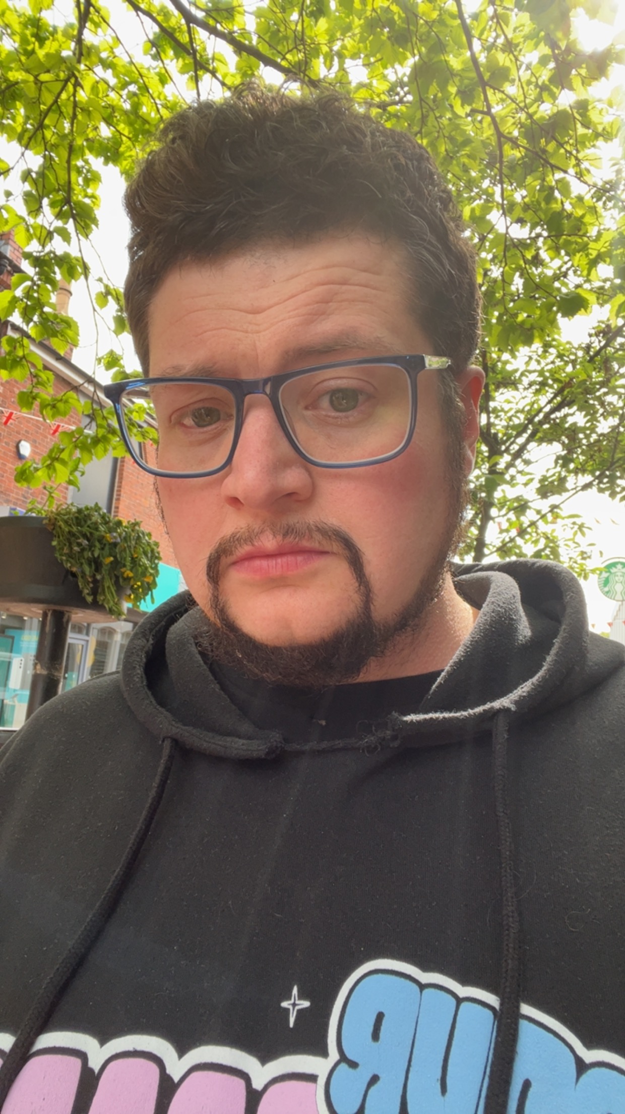 John, a Princess Diana stan, is pictured outdoors in a selfie.