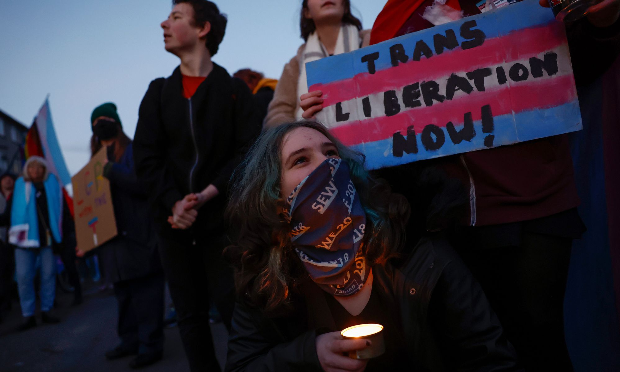 A person holds up a sign reading 