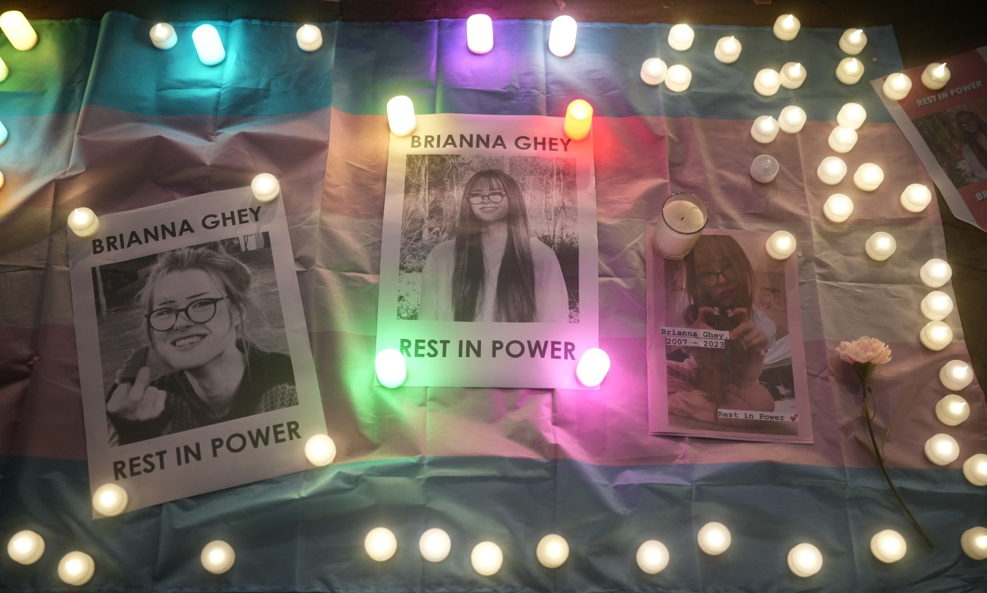 Candles are set next to pictures of Brianna Ghey, a trans teen who was fatally stabbed, in a vigil