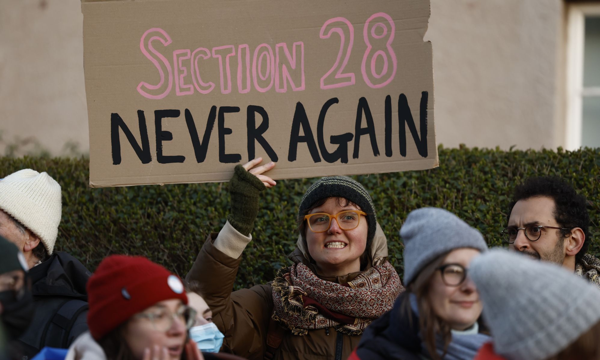 A person holds up a sign reading 