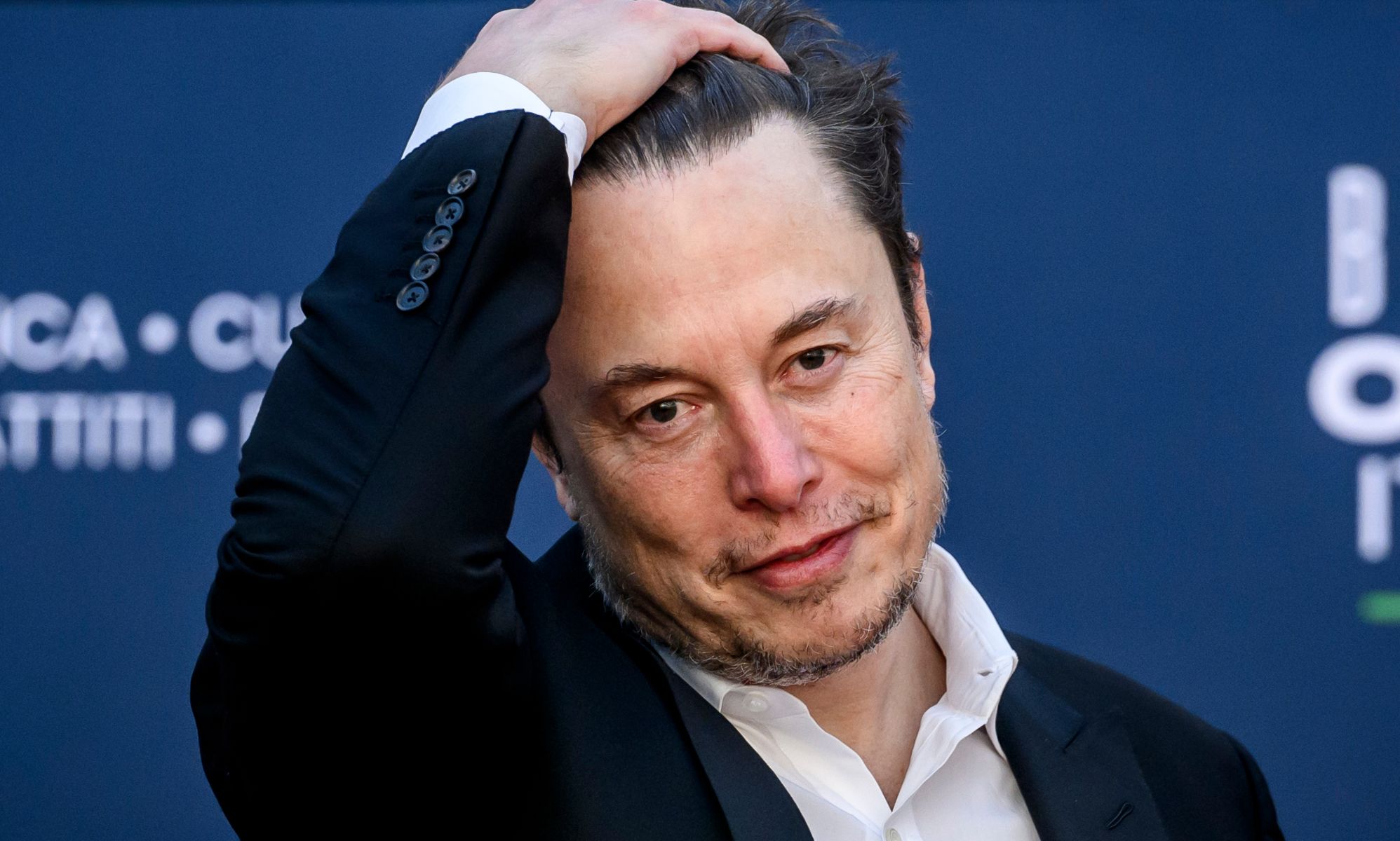 Elon Musk slicking his hair back.