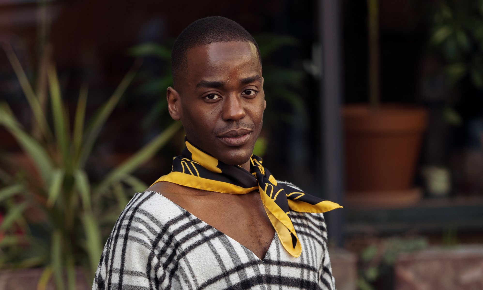 Ncuti Gatwa in a black and white shirt and black and yellow neck tie.