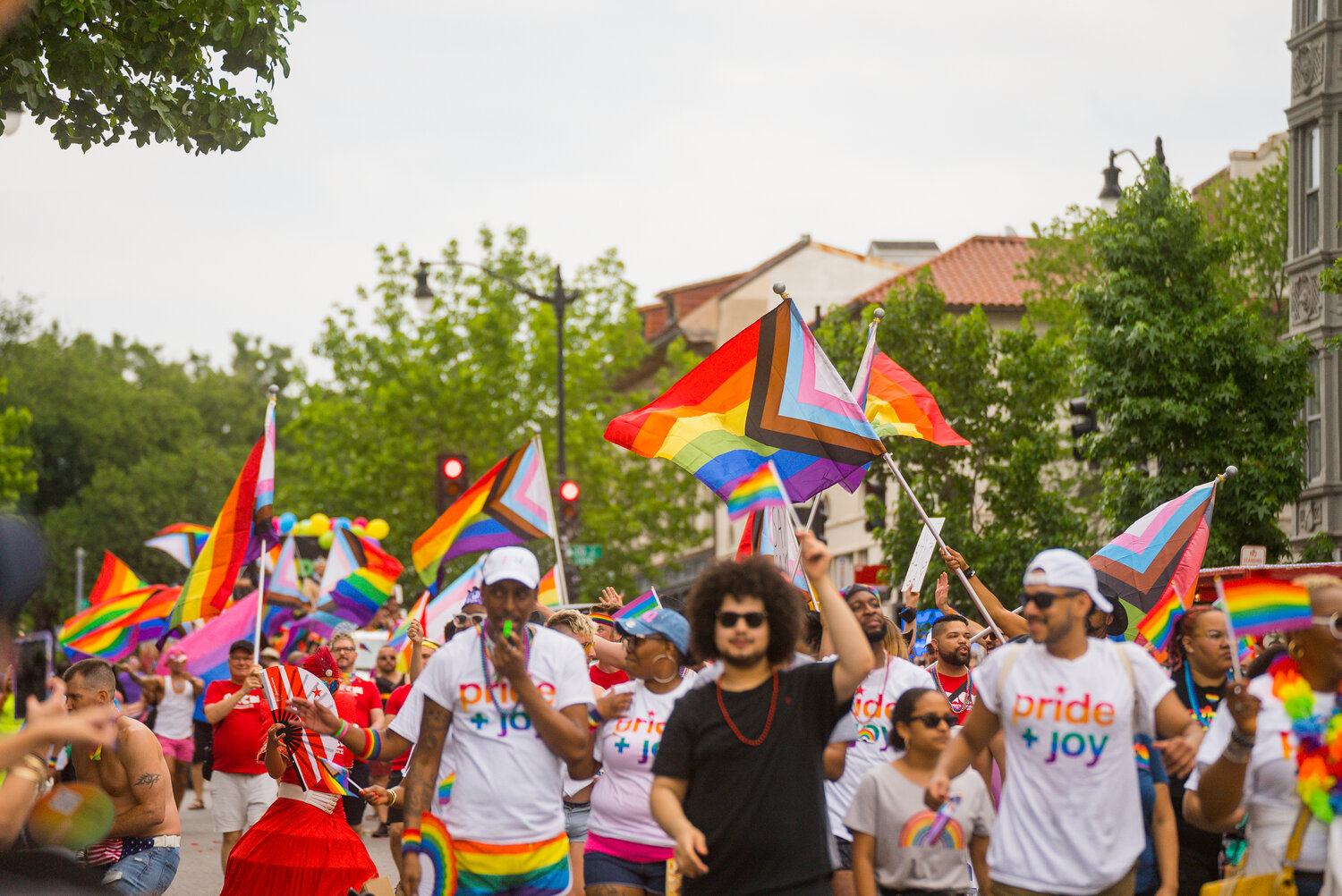 A crowd of people attending Pride, waving flags