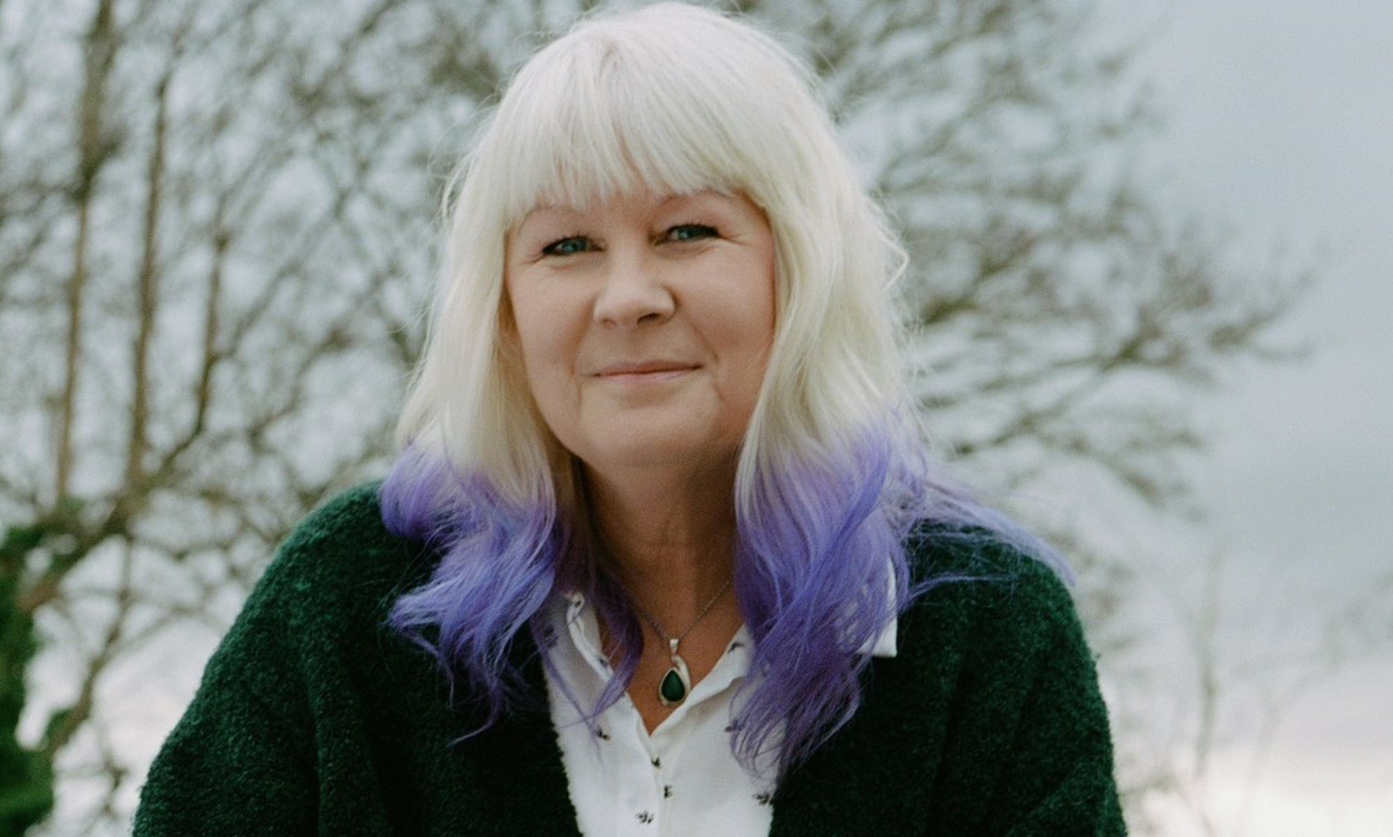 Susie Green outside, wearing a green sweater.