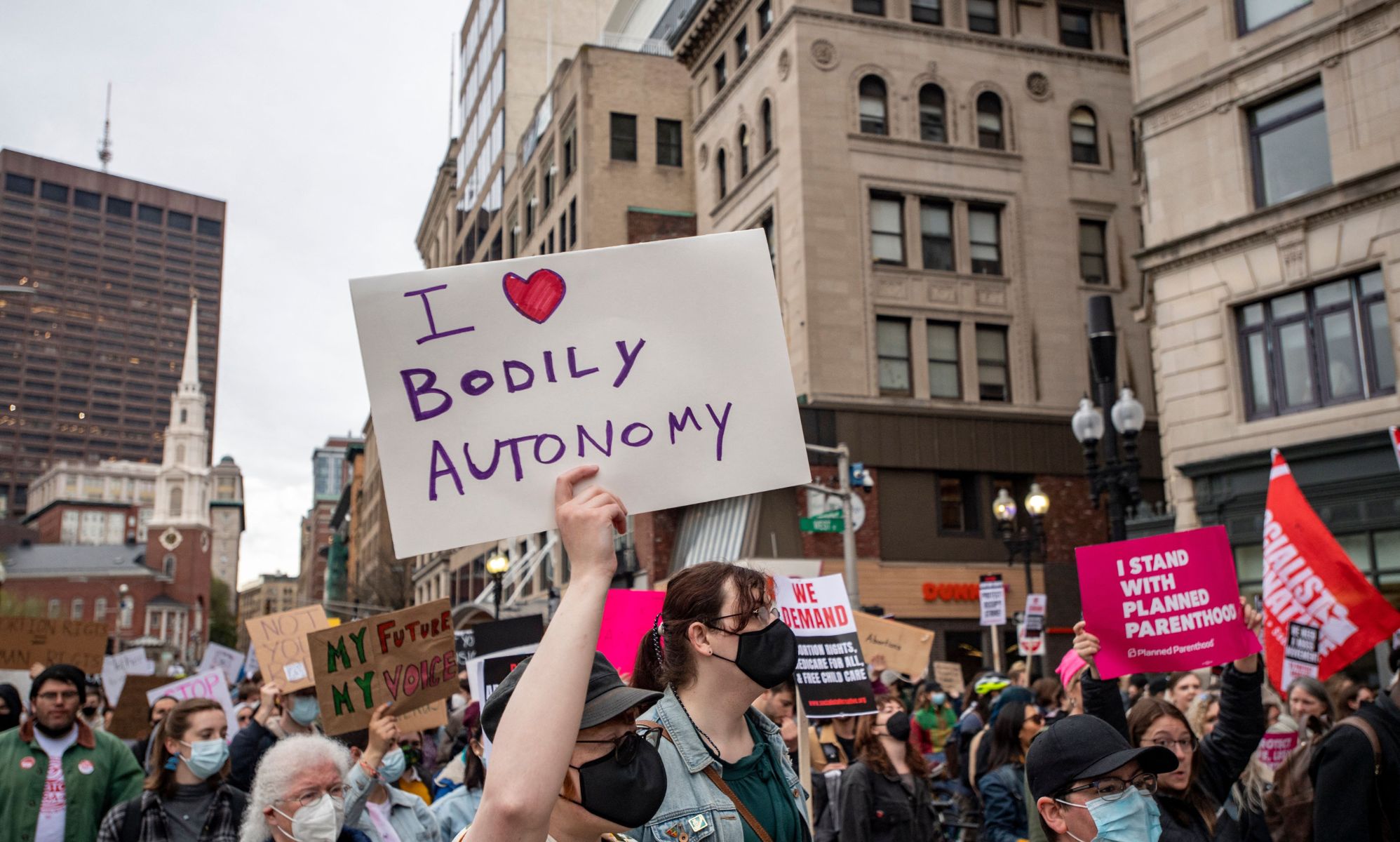 A person holds up a sign reading 