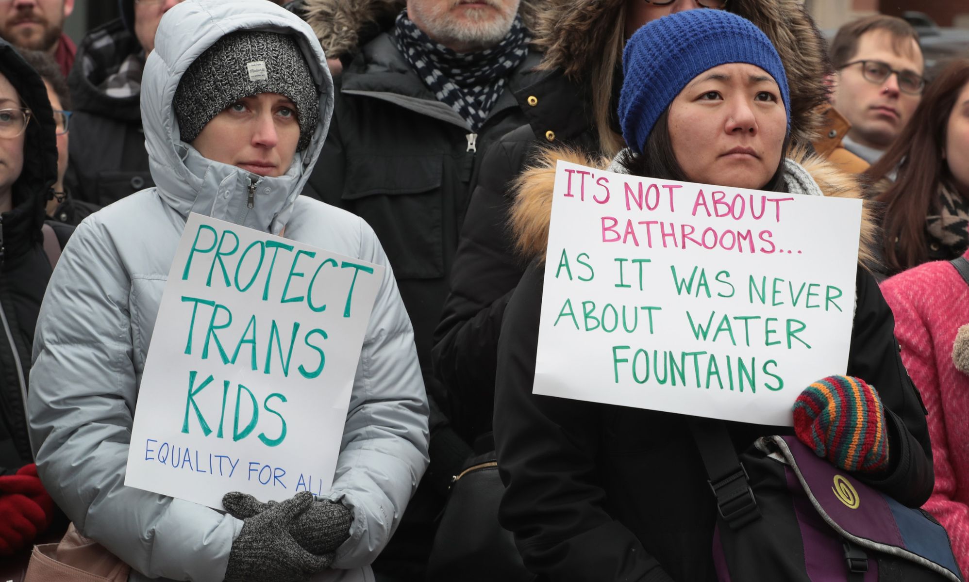 A person holds up a sign reading 