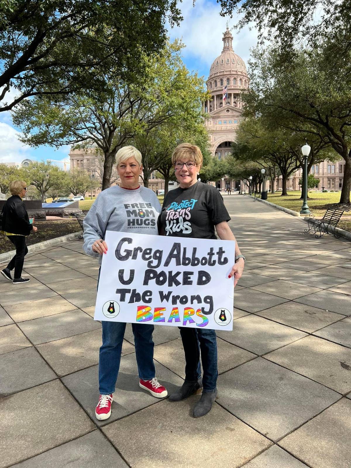 Mama Bears, a support network for moms of LGBTQ+ youth, founder Liz Dyer holds up a sign reading 