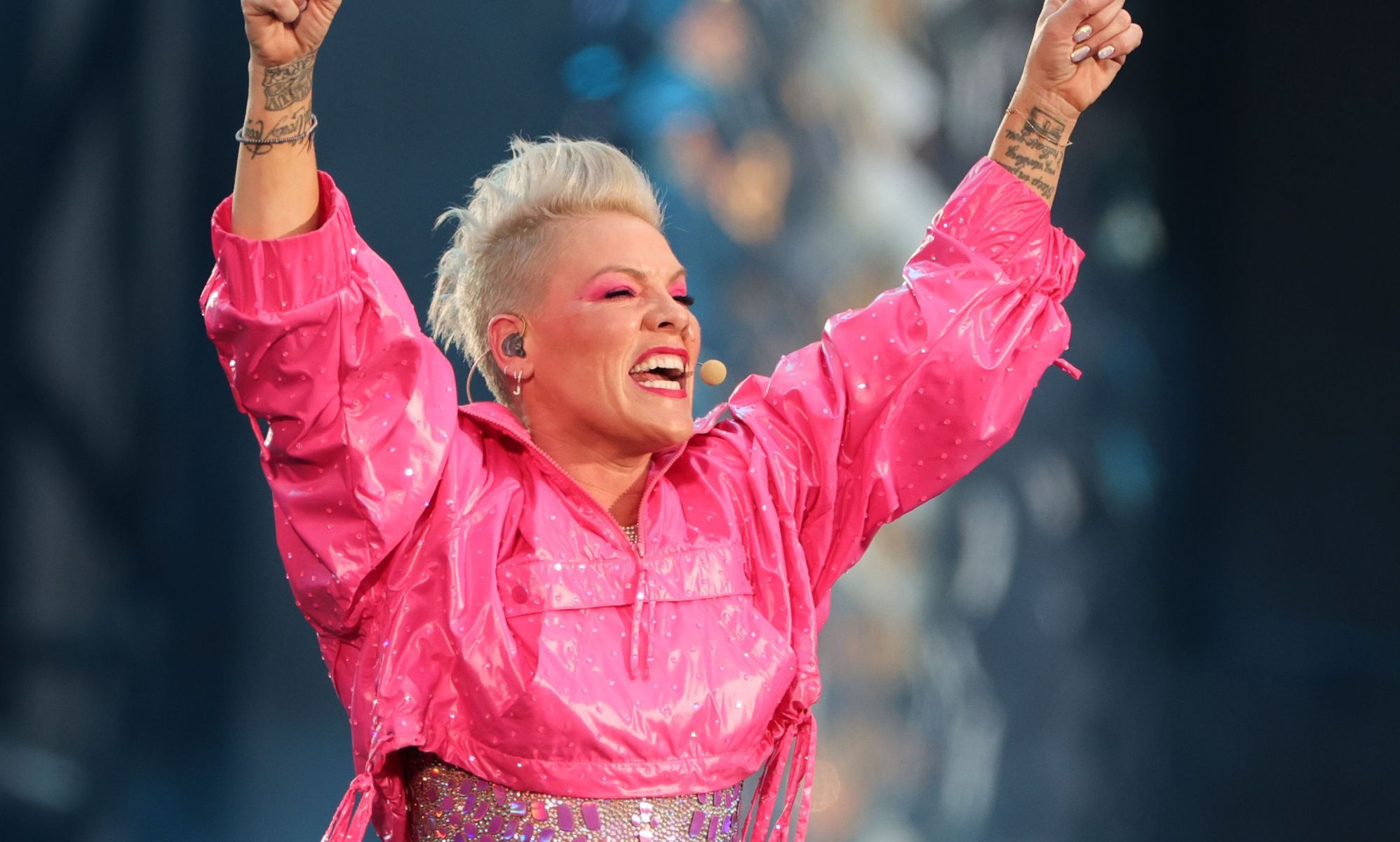 Pink, arms raised, sings into an ear-piece microphone.