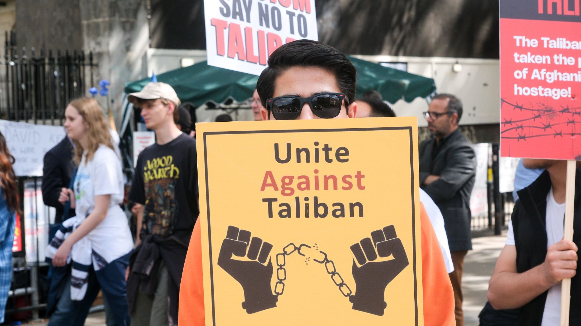 Protester holds up a sign reading &quot;unite against Taliban&quot;