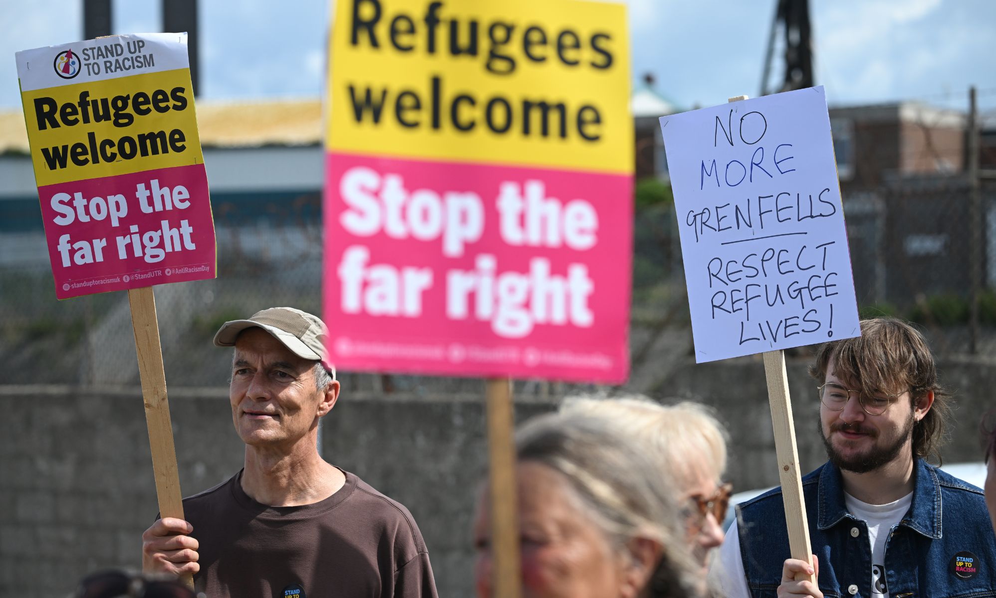 A person holds up a sign reading 