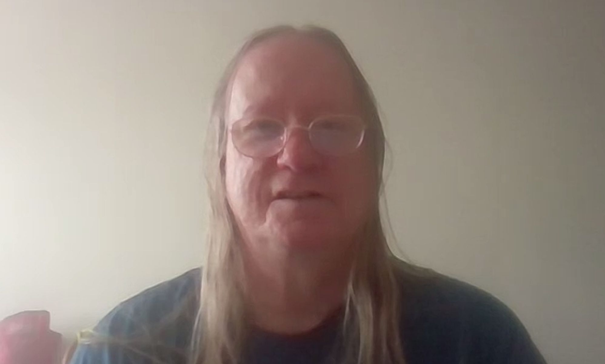 Reina, a trans woman who came out as an elder, wears a grey shirt as she smiles for the camera during a video chat