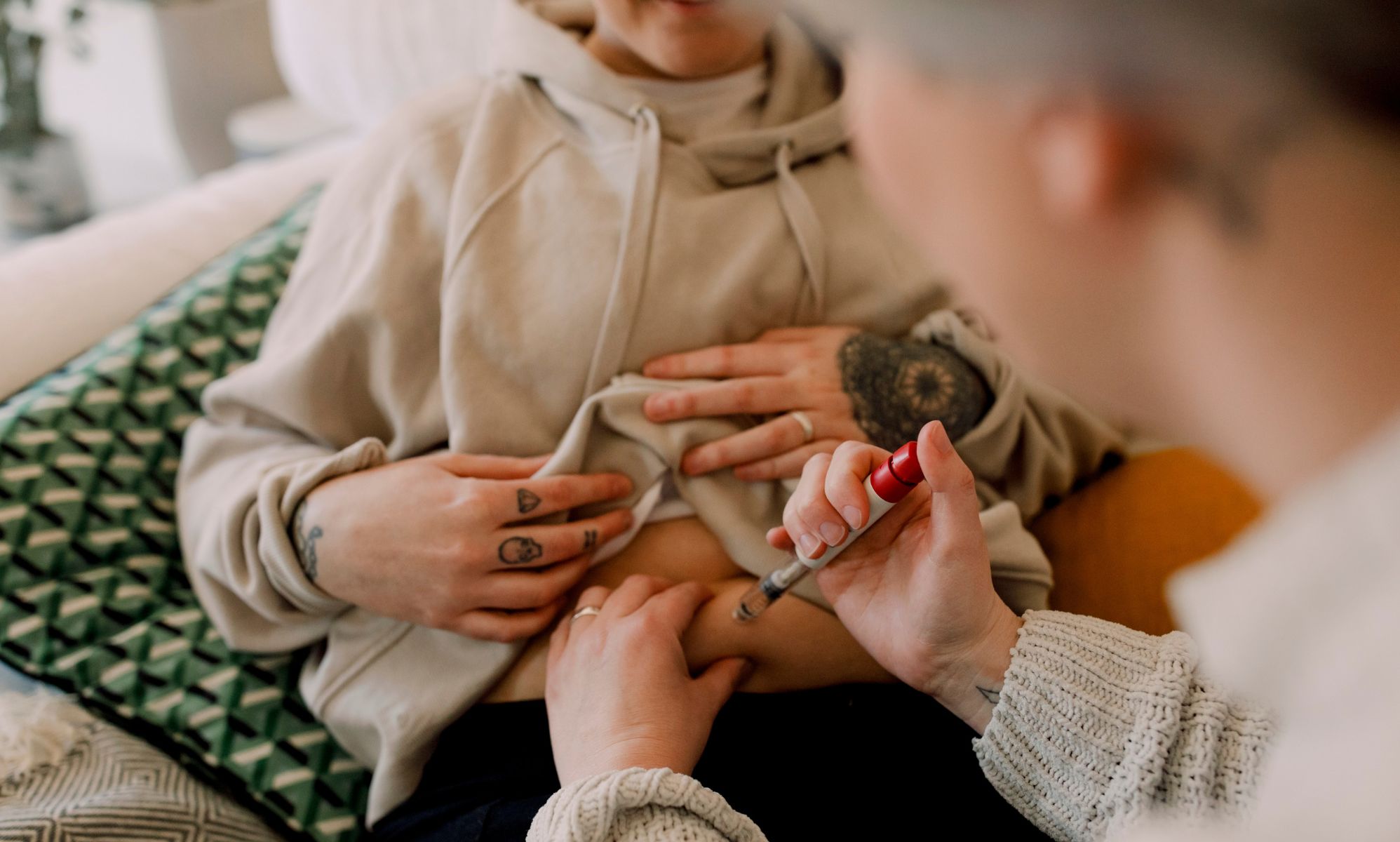 A couple uses a needle to inject the others stomach as part of an IVF treatment.