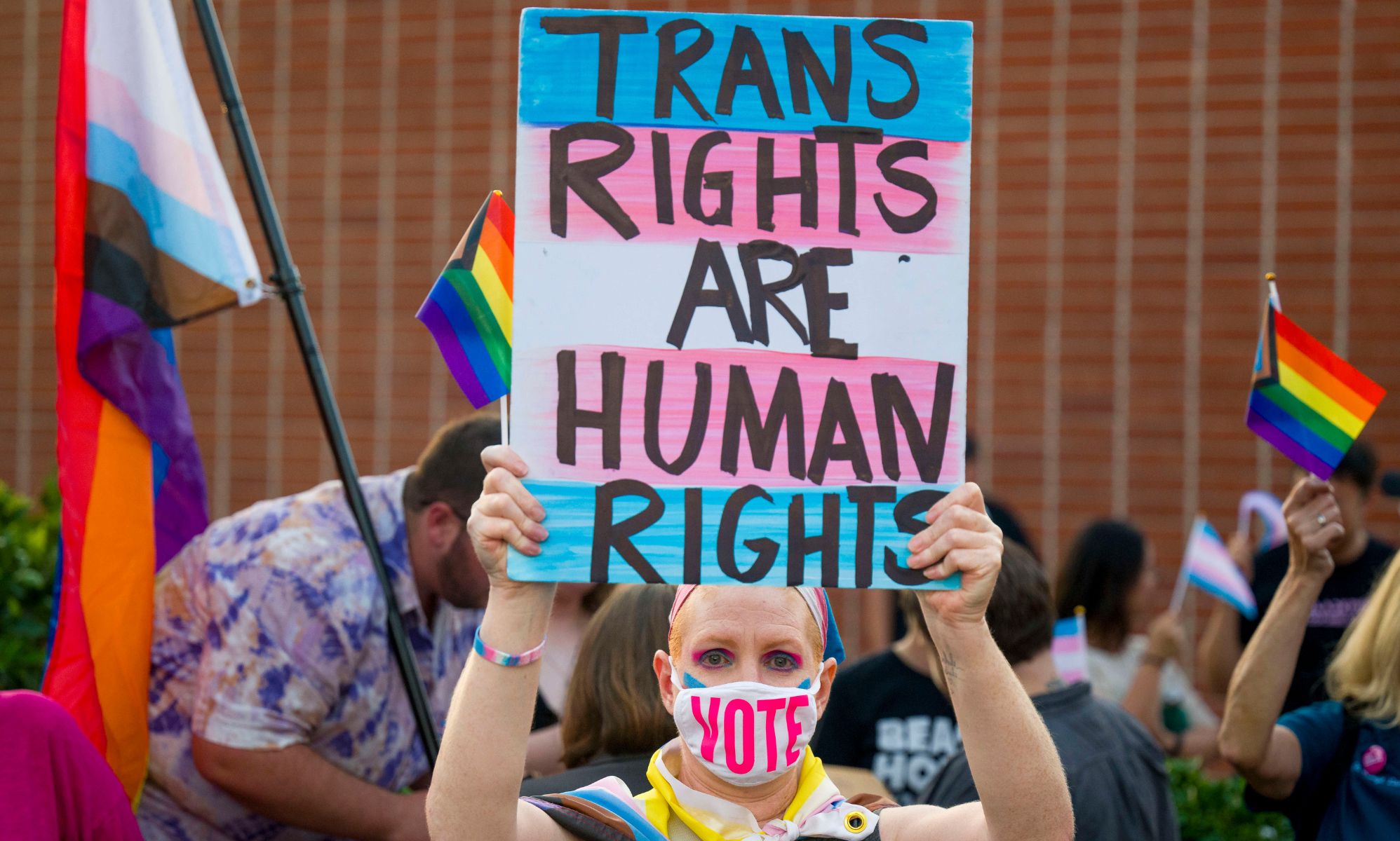 Person holds up a sign reading &quot;trans rights are human rights&quot; at a protest in California