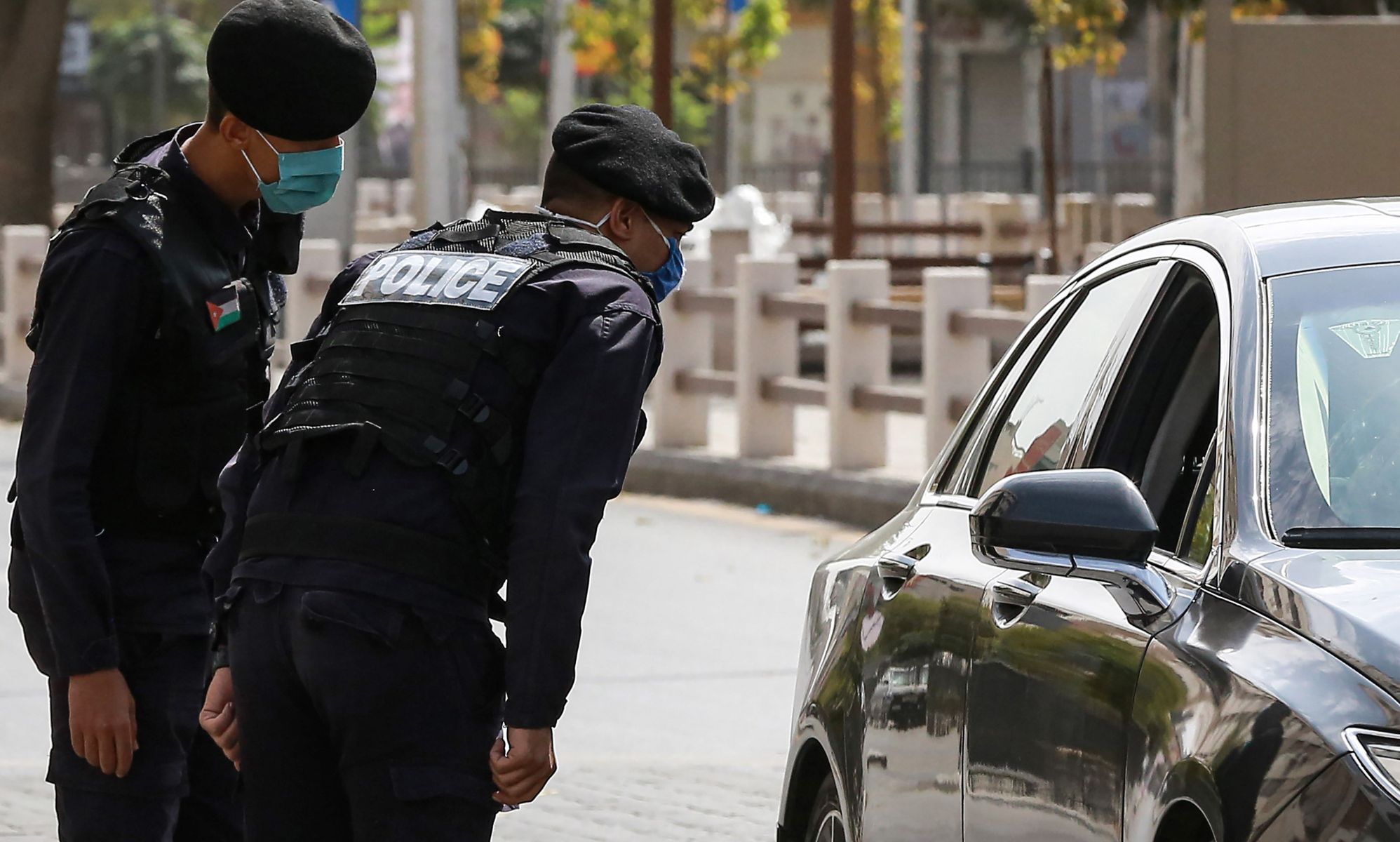 Police approach a car in Jordan.