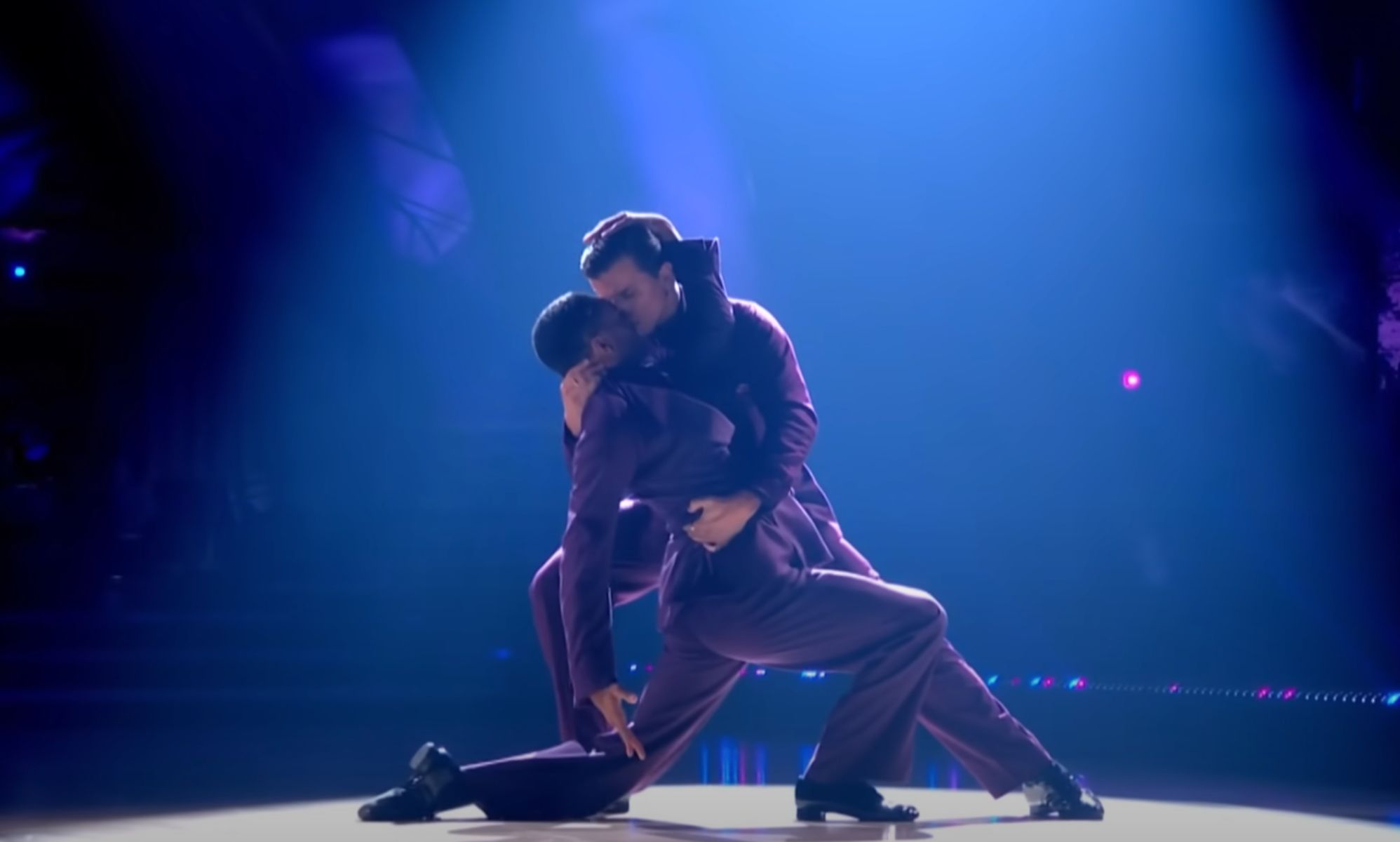 Layton Williams and Nikita Kuzmin wear matching purple outfits as they hold each other close and dance together during a performance on BBC