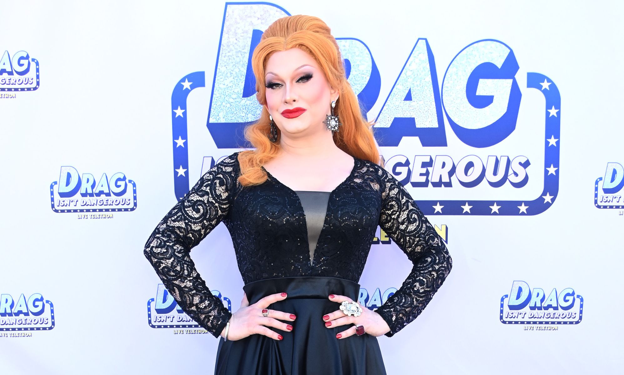 Drag Race superstar Jinkx Monsoon poses while wearing a black and grey dress