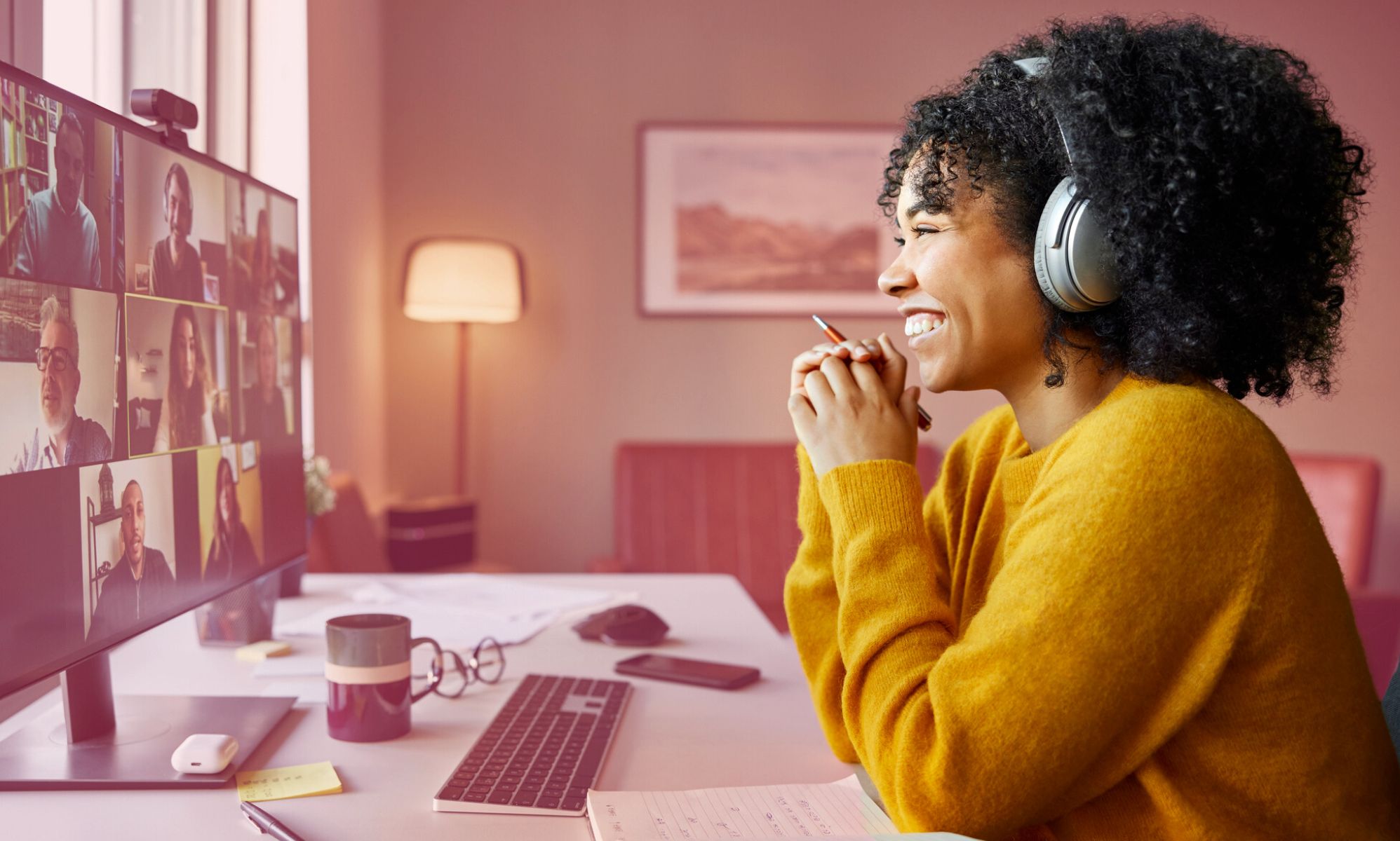 This is an image of a Black woman sitting at a computer in her home. She is on a Zoom call.