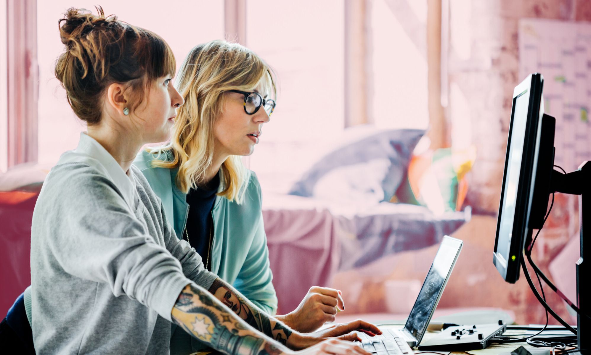 This is an image of two women working at a computer.