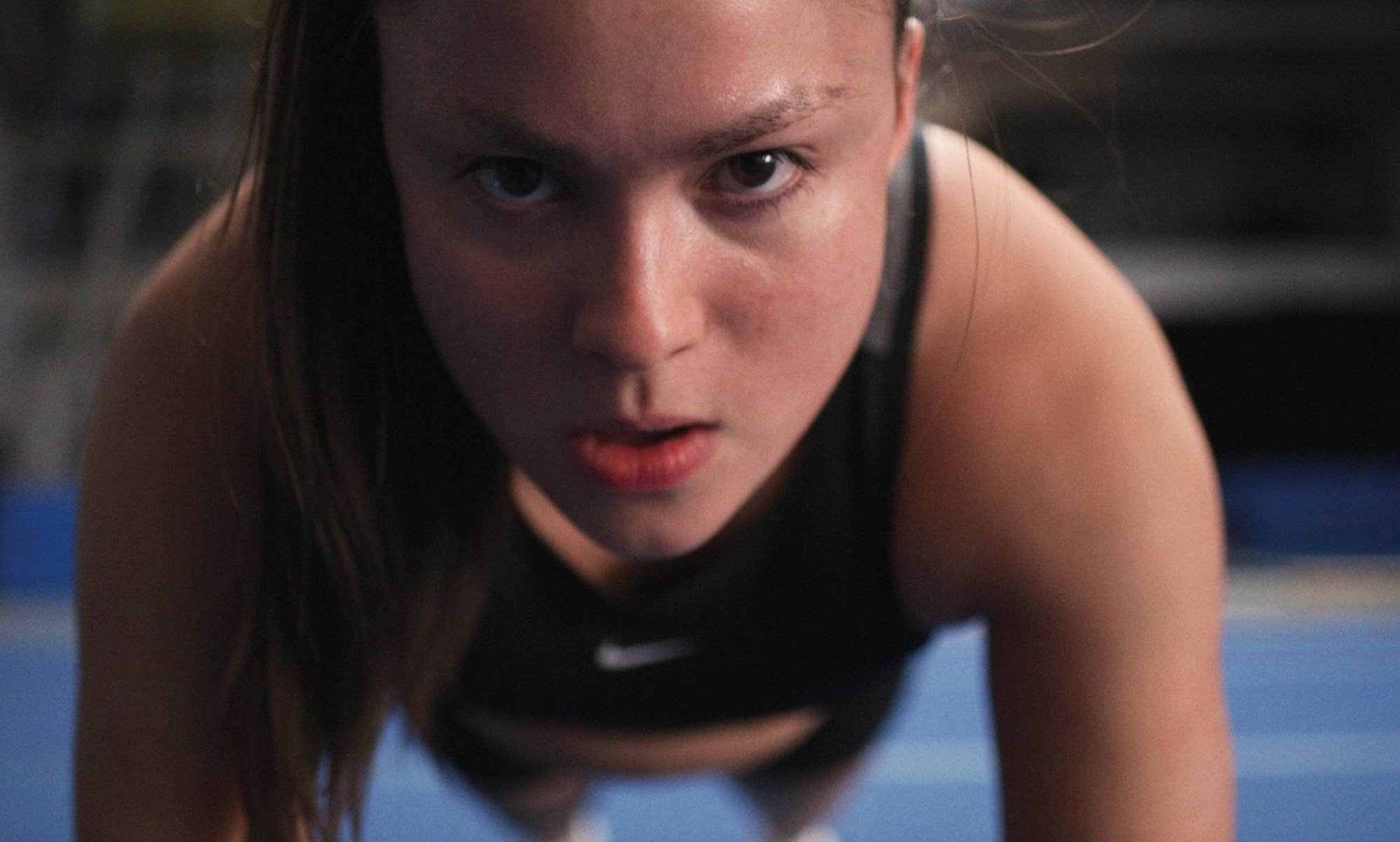 A still from the trailer of Backspot featuring Devery Jacobs as Riley doing a push up