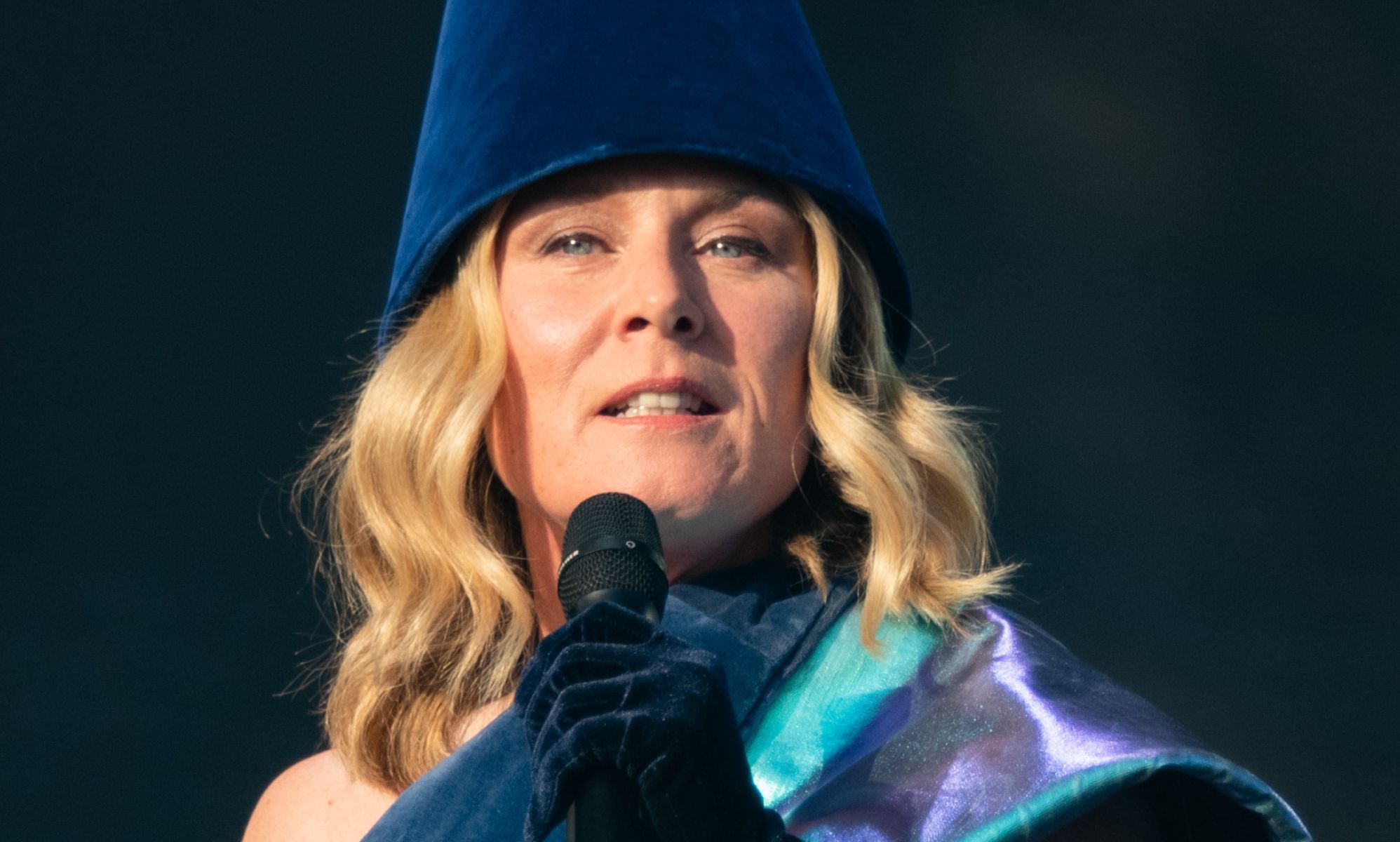 Róisín Murphy singing into a microphone while on stage at a concert.