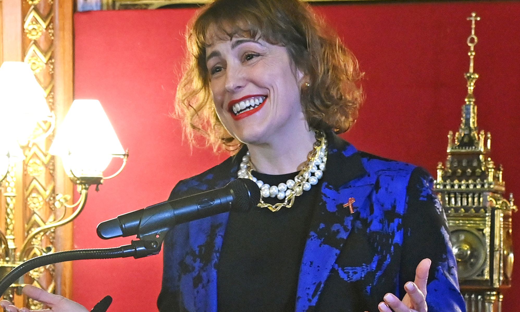 Victoria Atkins in a blue coat, speaking in a Parliament room.