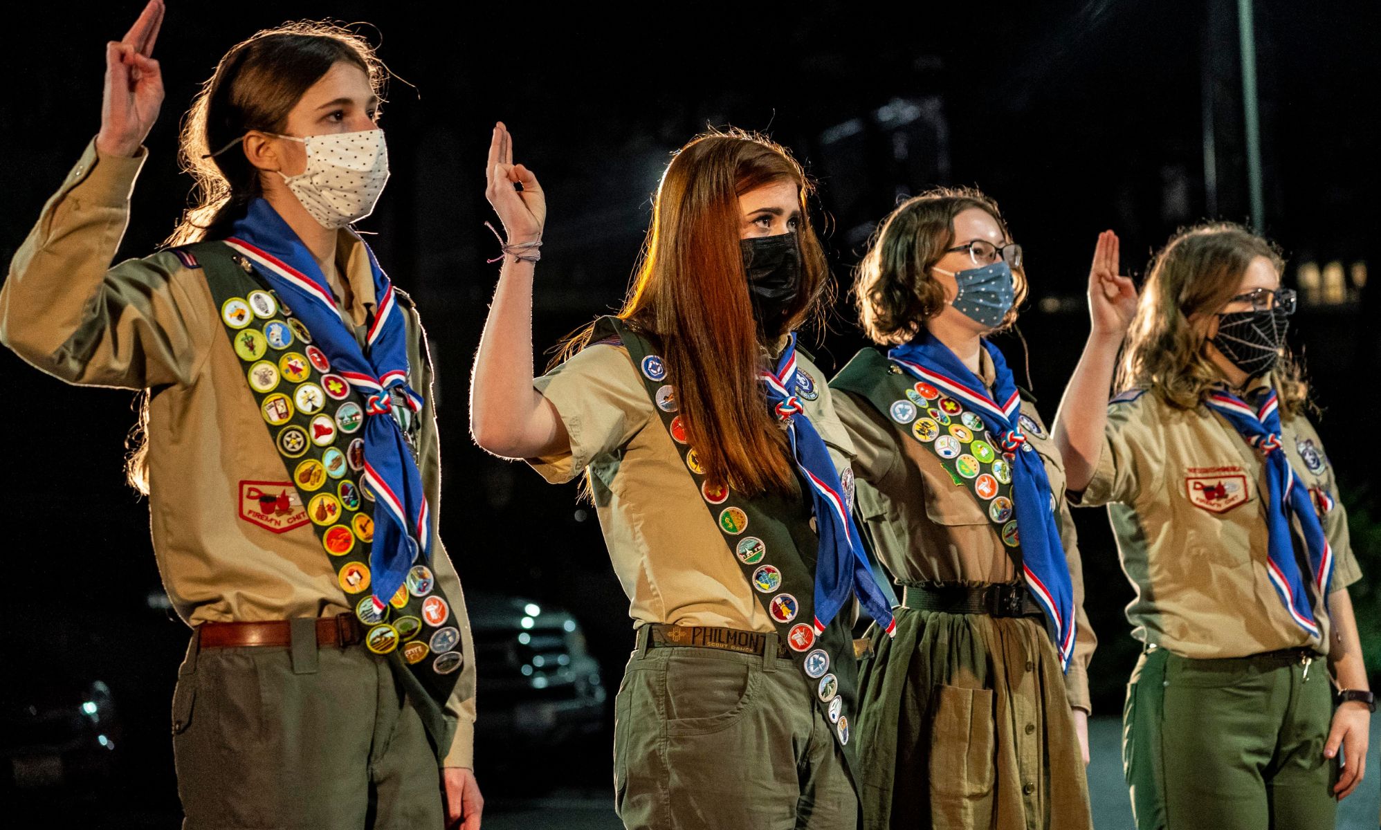 Girl members of the Boy Scouts of America stand in a line.