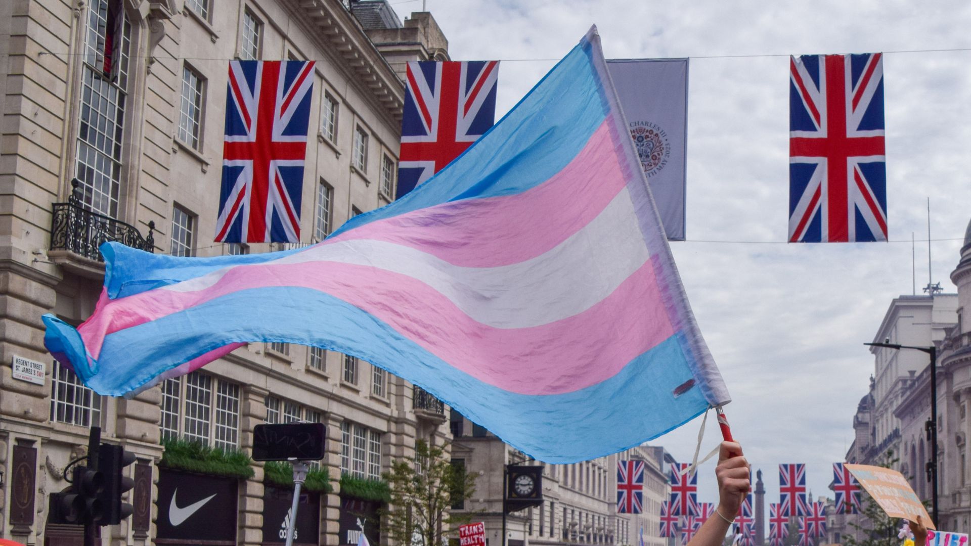 A protester holds a trans pride flag during a demonstration in Piccadilly Circus, London