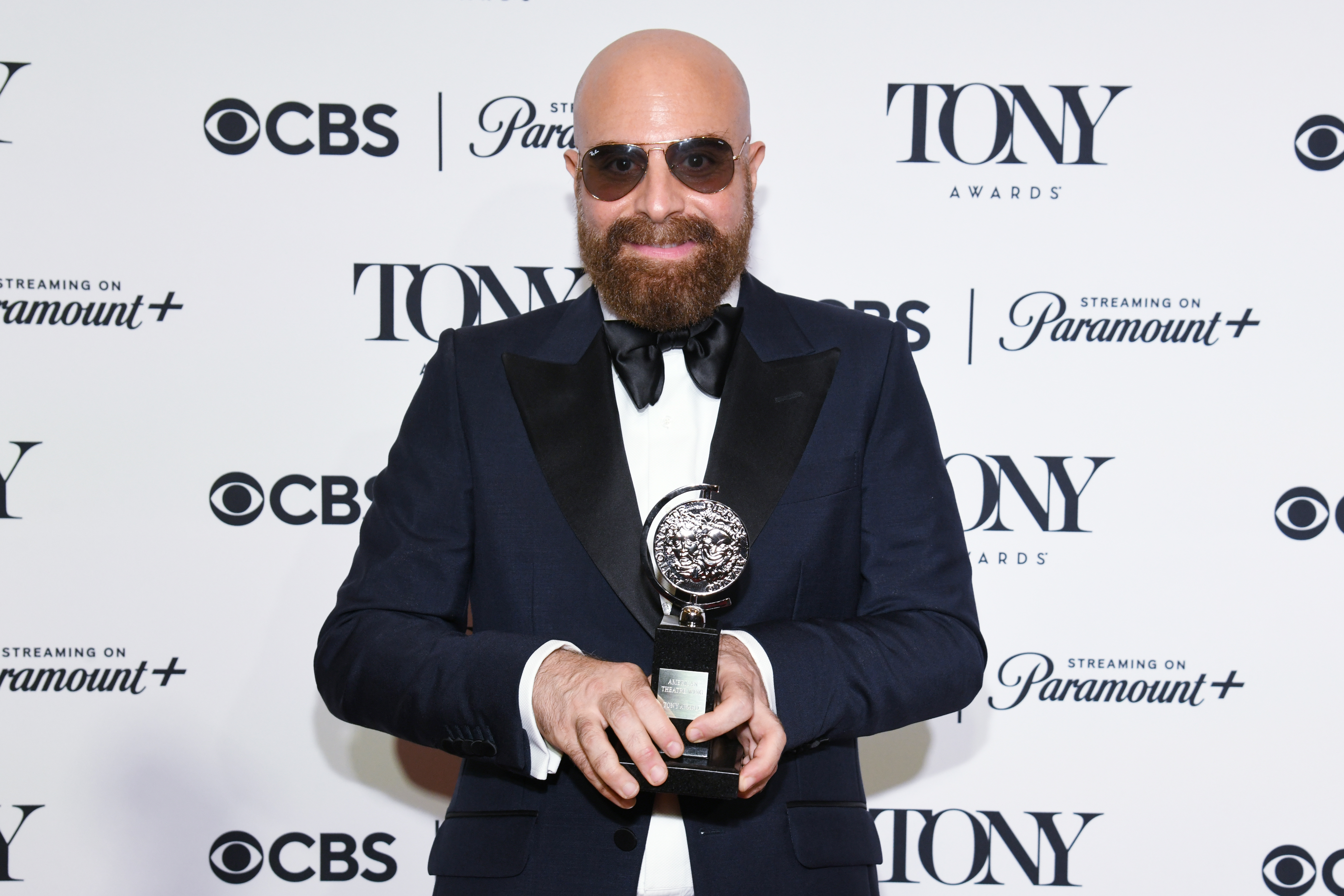 David Adjmi posing with his Tony Award