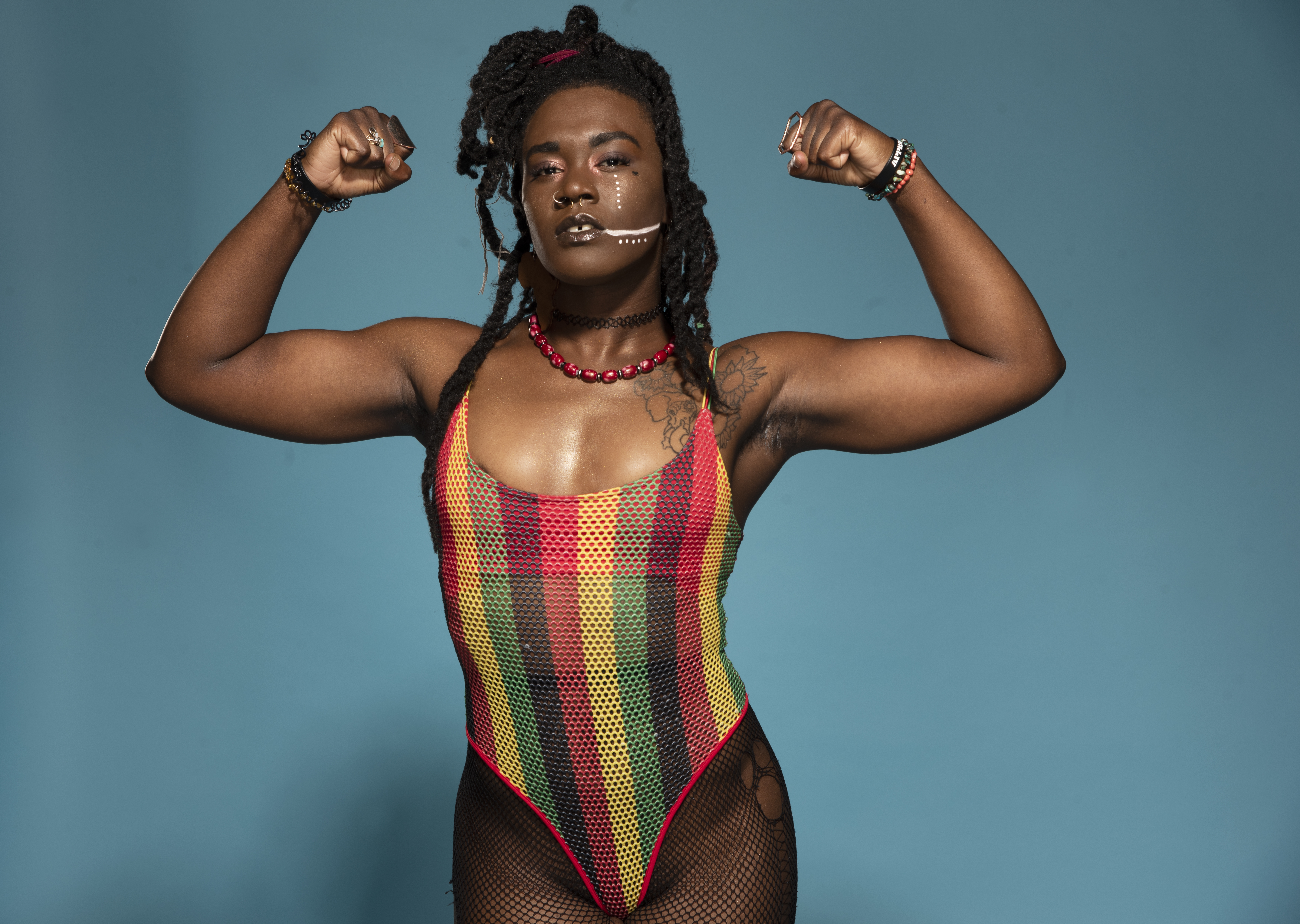 Trish Adora posing with her arms flexed in the air