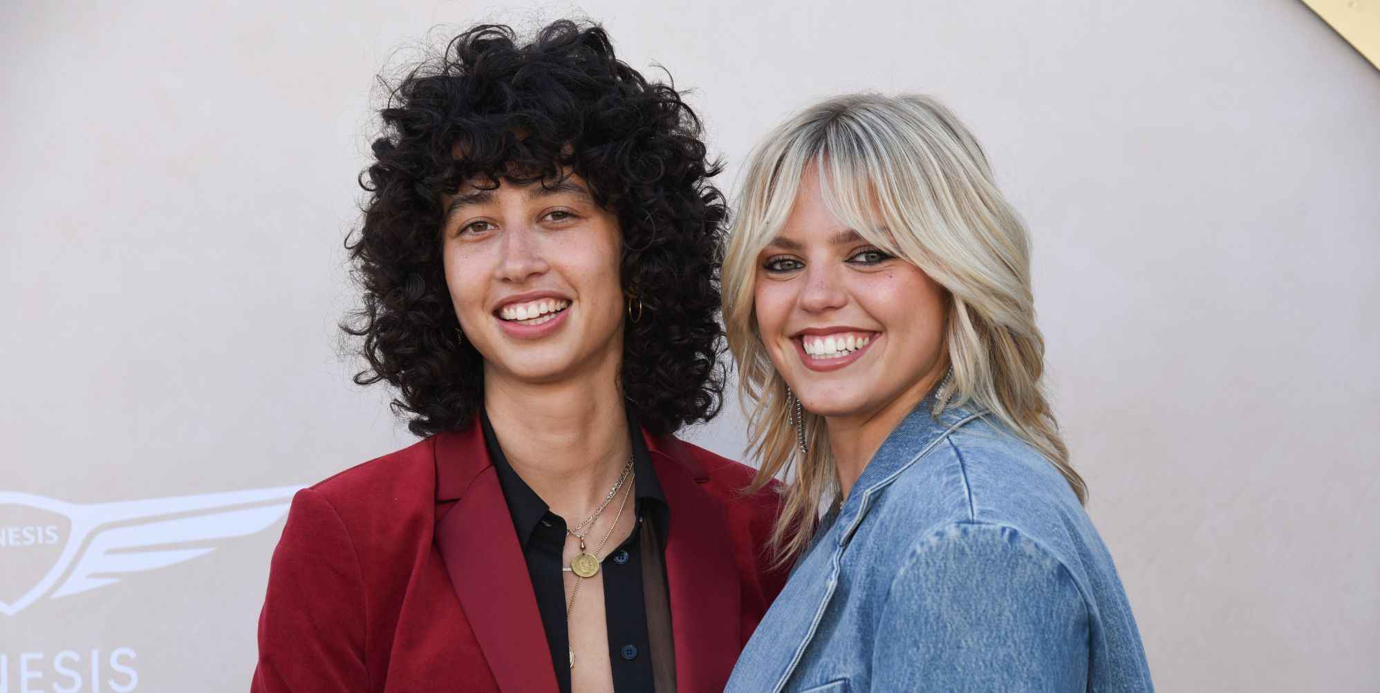 Towa Bird and Reneé Rapp in blue and red suits.