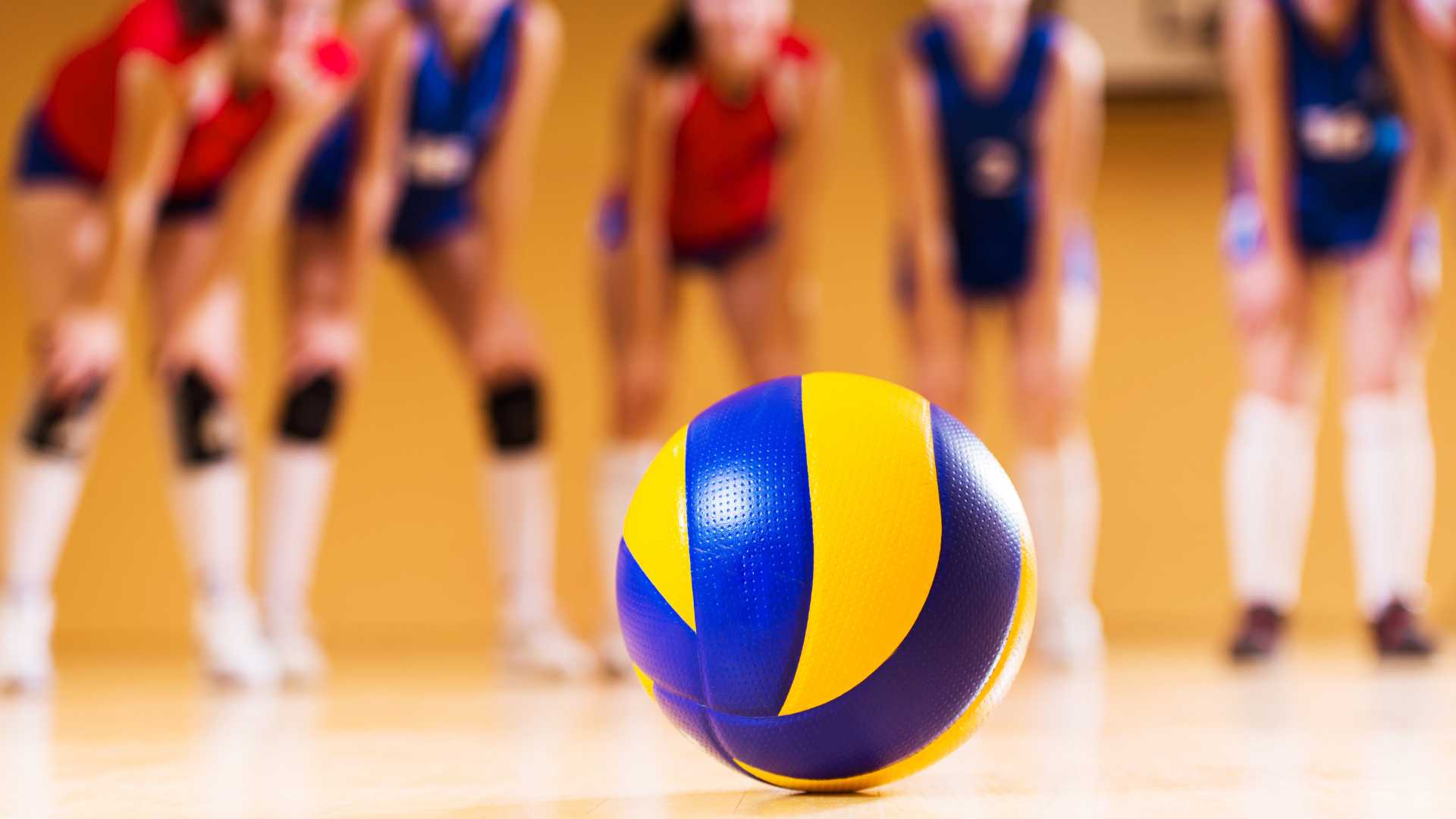 A volleyball ball surrounded by players.