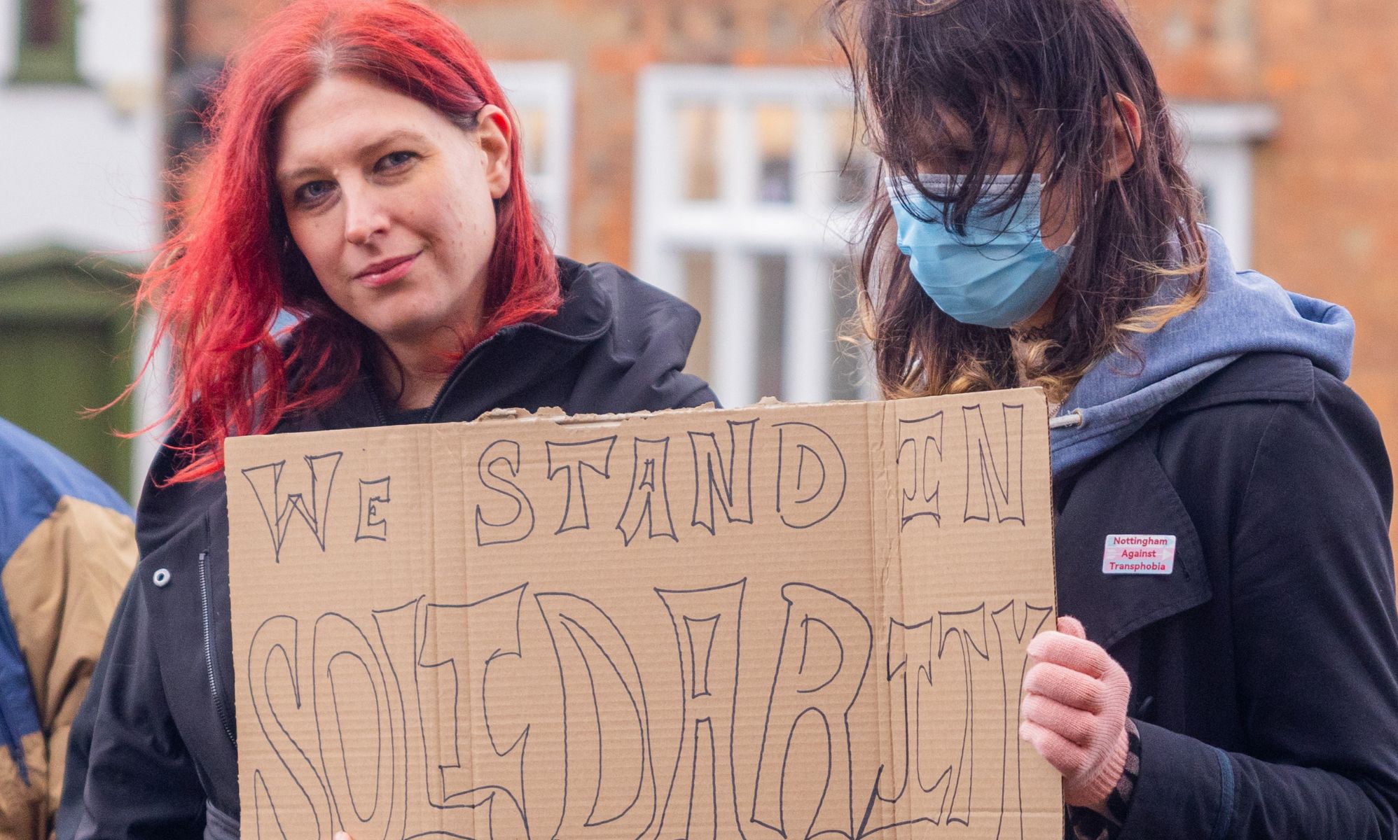Two protestors holding a sign that reads 