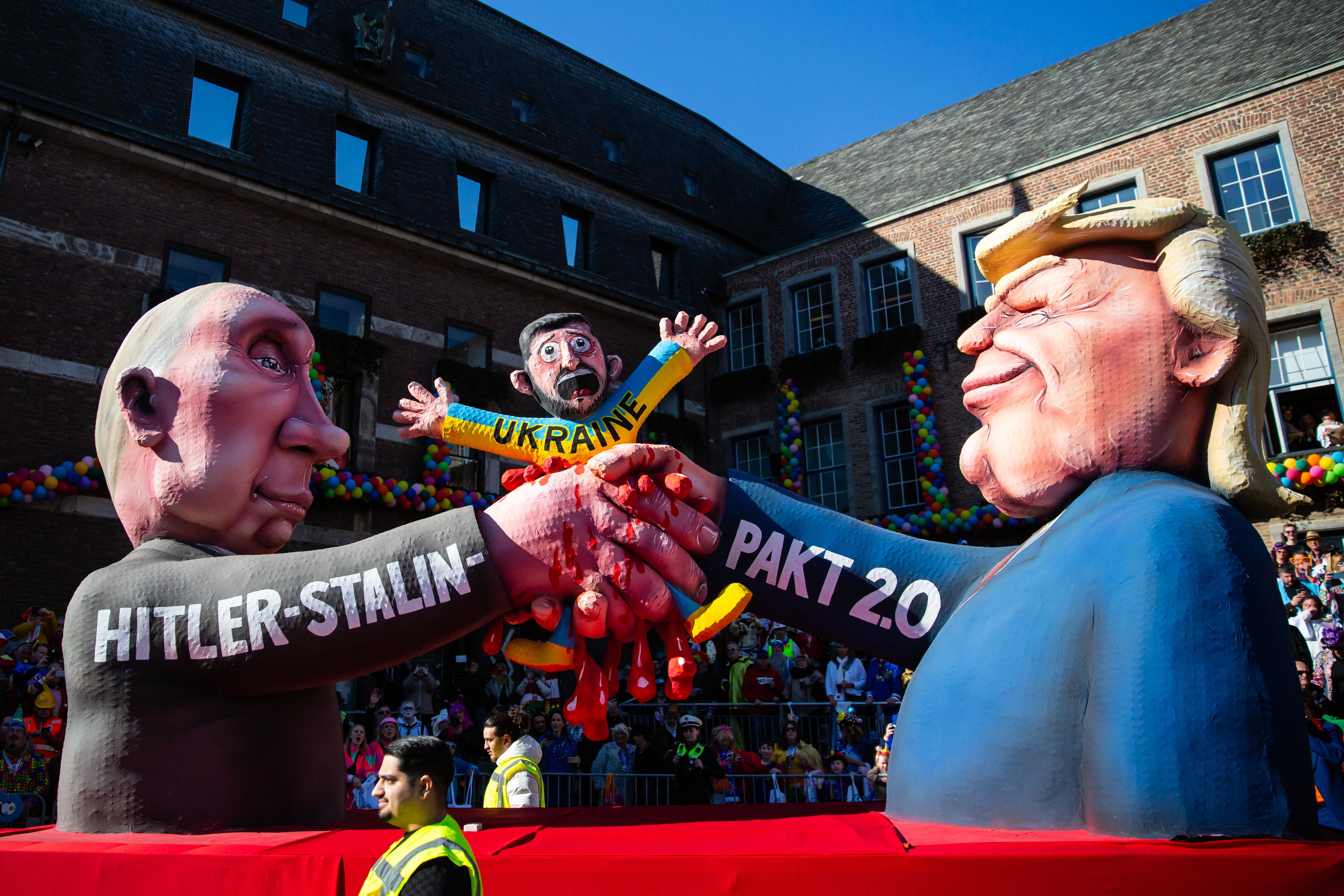 A carnival float shows Donald Trump and Russian president Vladimir Putin crushing Ukrainian president Volodymyr Zelenskyy while shaking hands during the annual Rose Monday parade.
