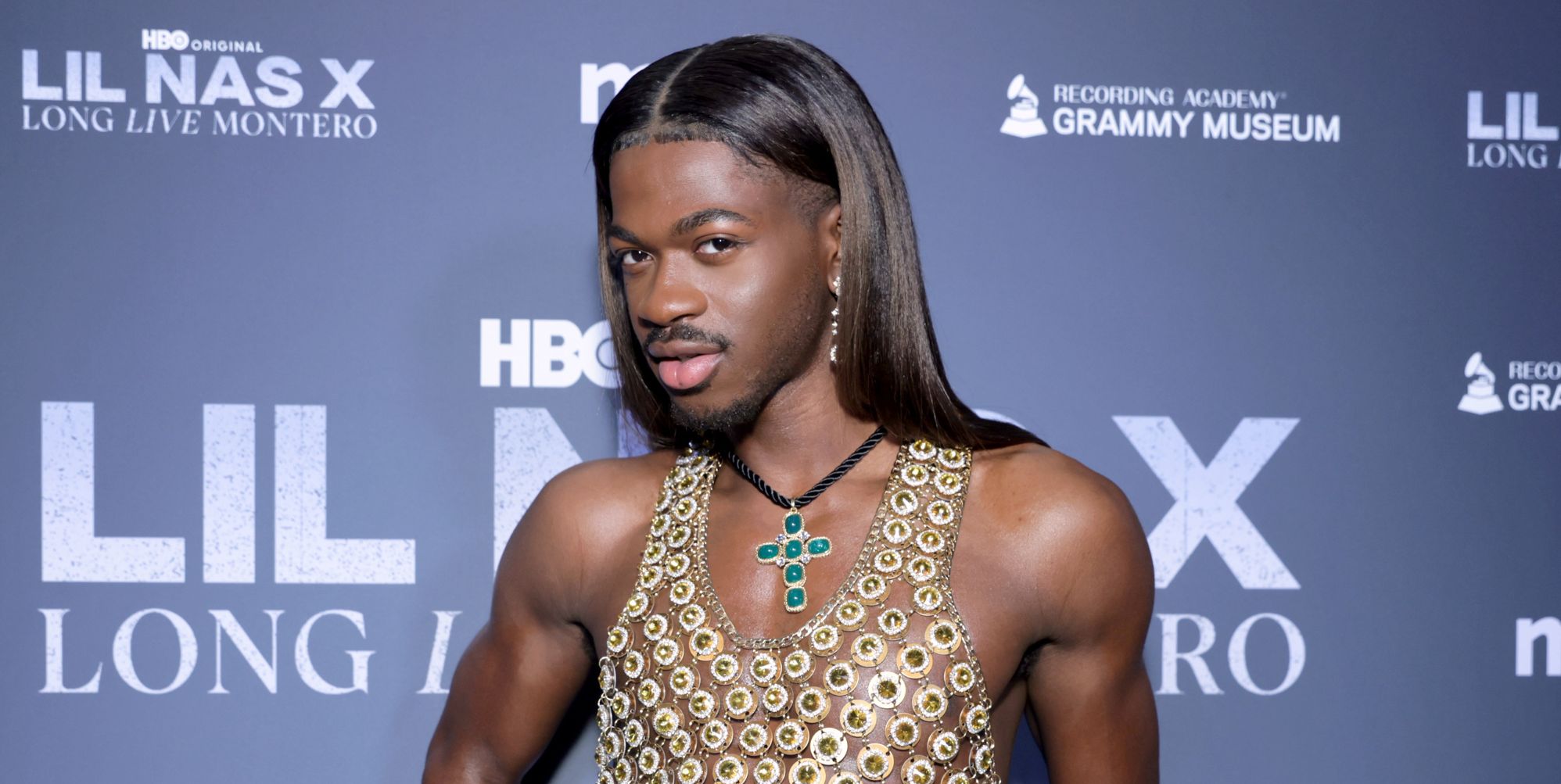 Lil Nas X poses on a red carpet in 2024.