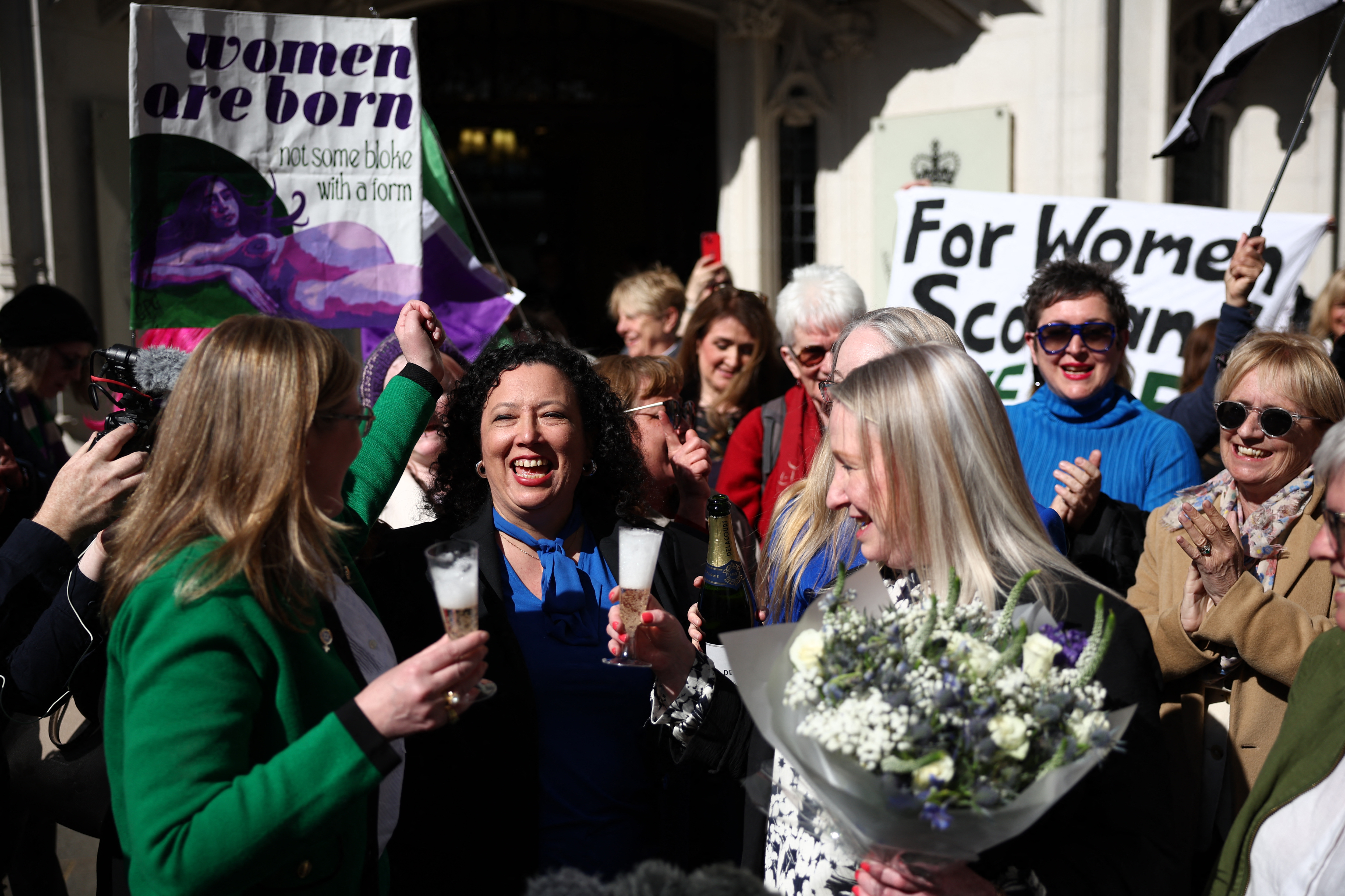 Susan Smith (L) and Marion Calder (3R), Directors of For Women Scotland, celebrate with Maya Forstater of 