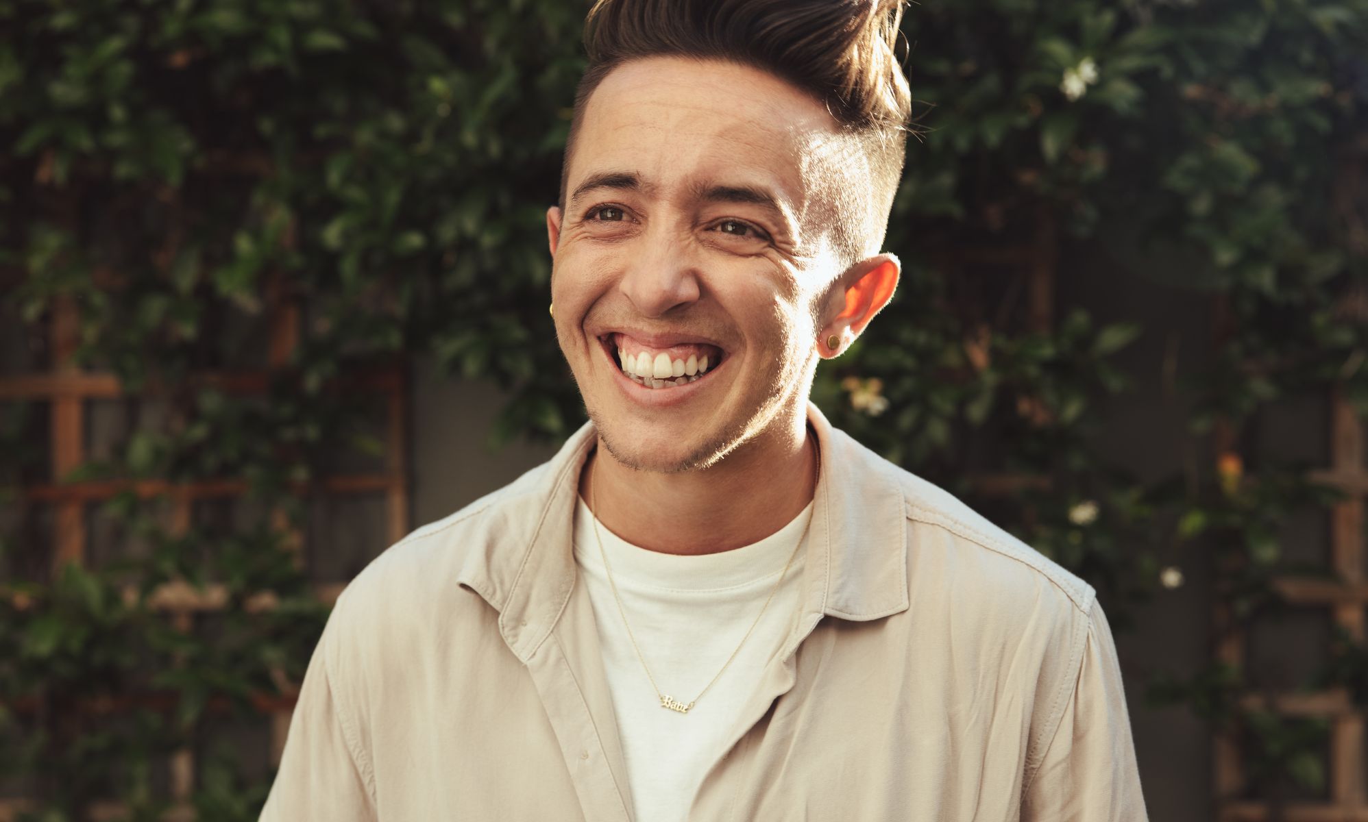 A trans man laughing.