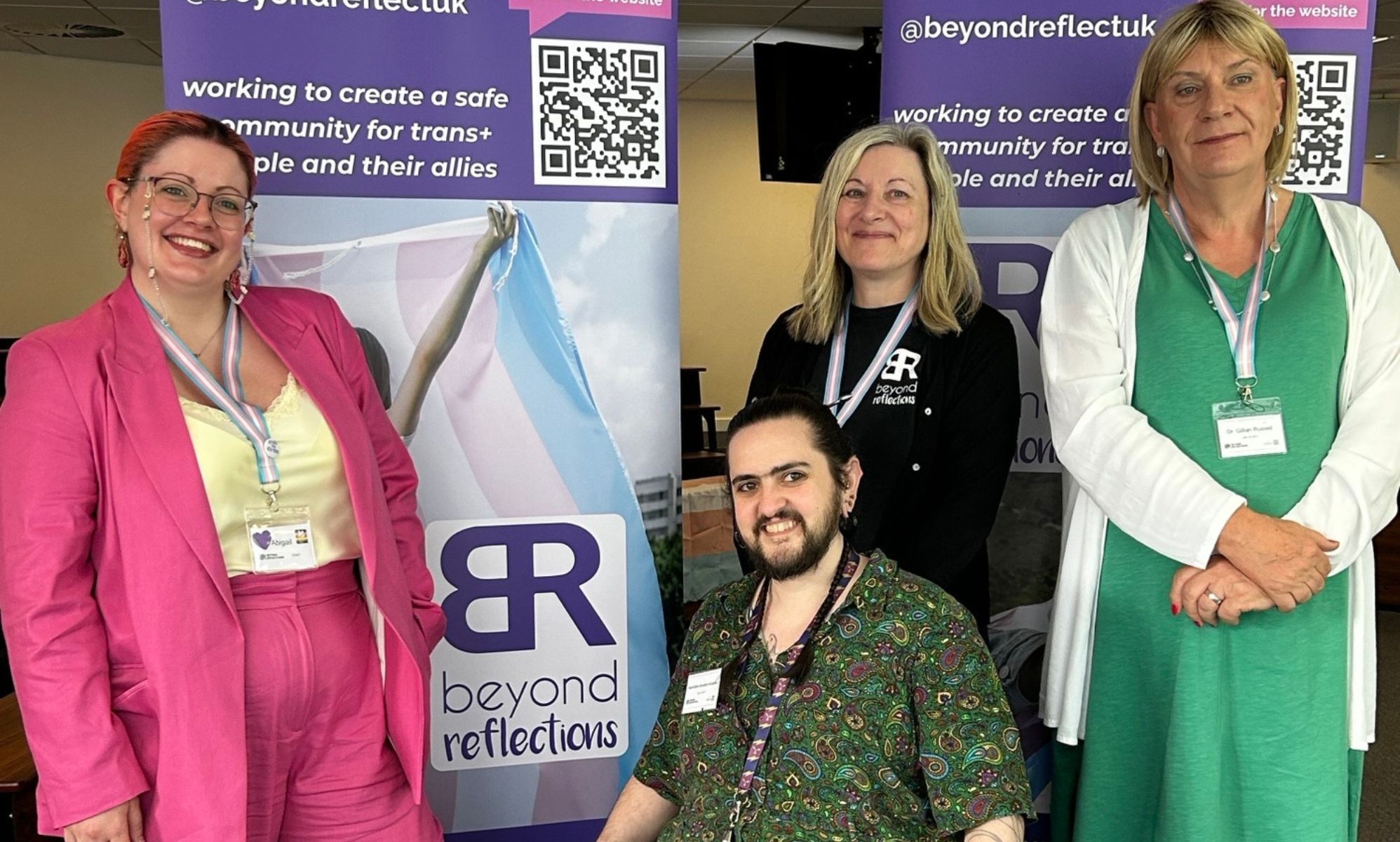The core team at Beyond Reflections standing in front of banners.