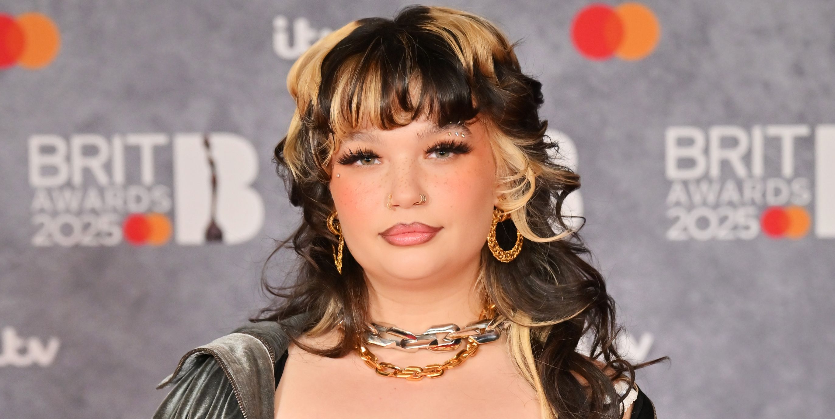 Lola Young poses for photos on the BRIT Awards red carpet