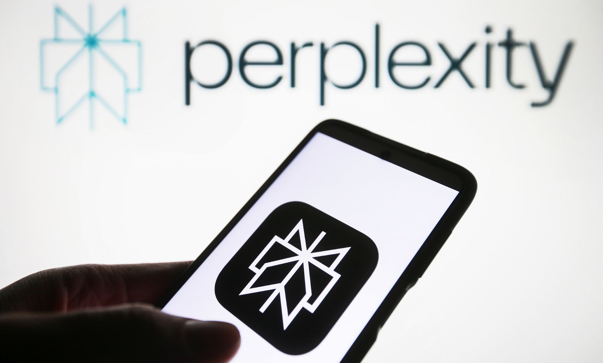 A phone showing a Perplexity AI app logo.