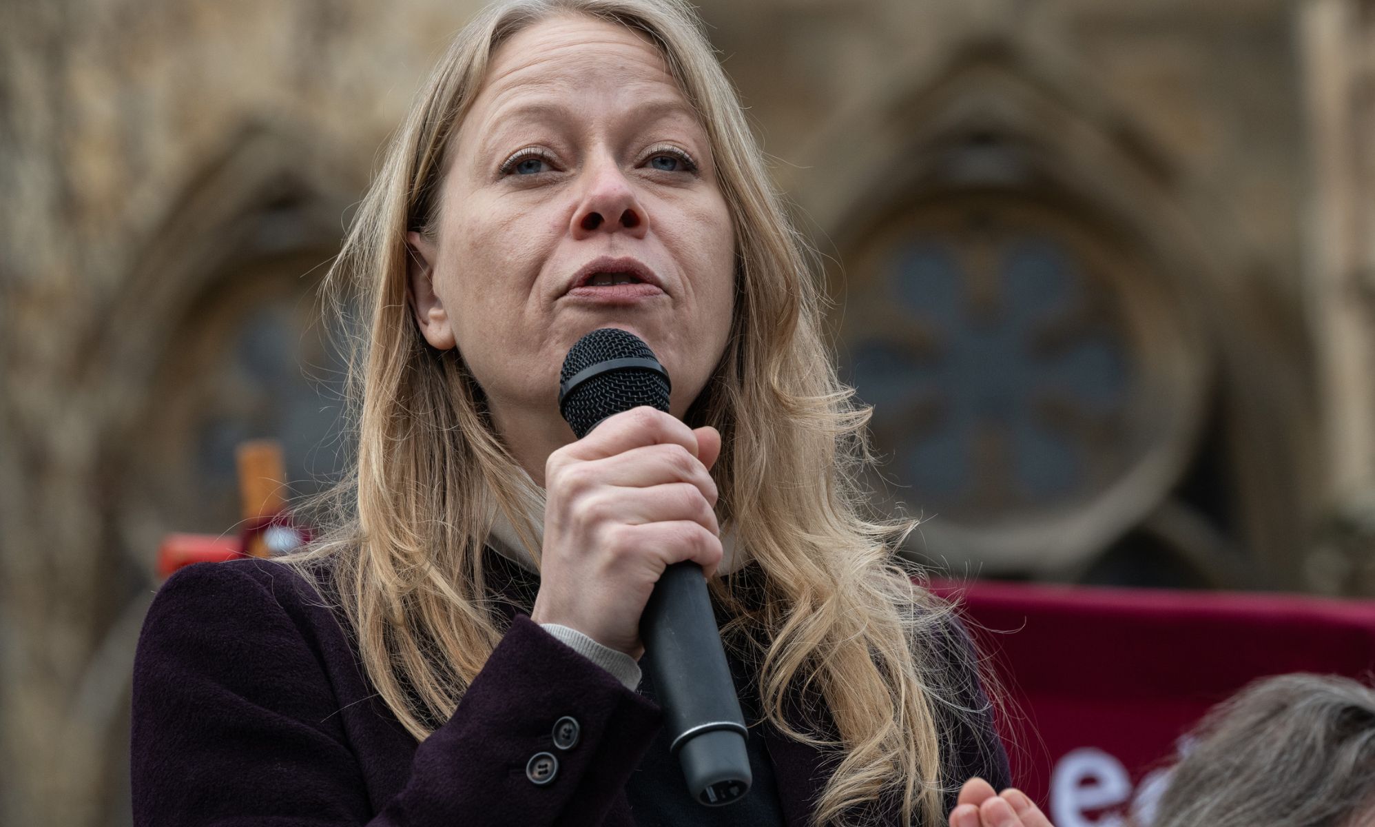 Greens MP Sian Berry pictured holding a microphone.