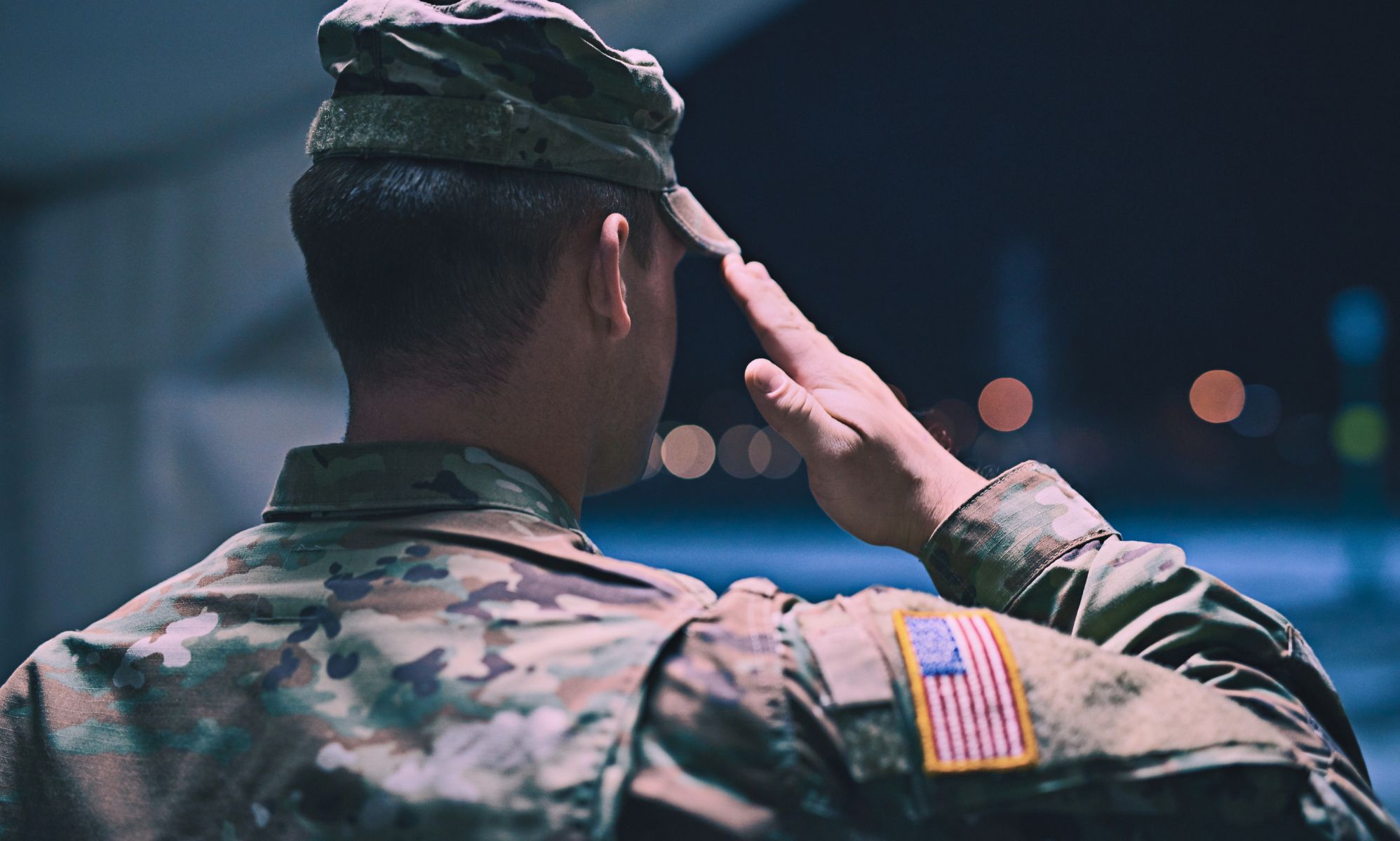 The back profile of a soldier saluting.