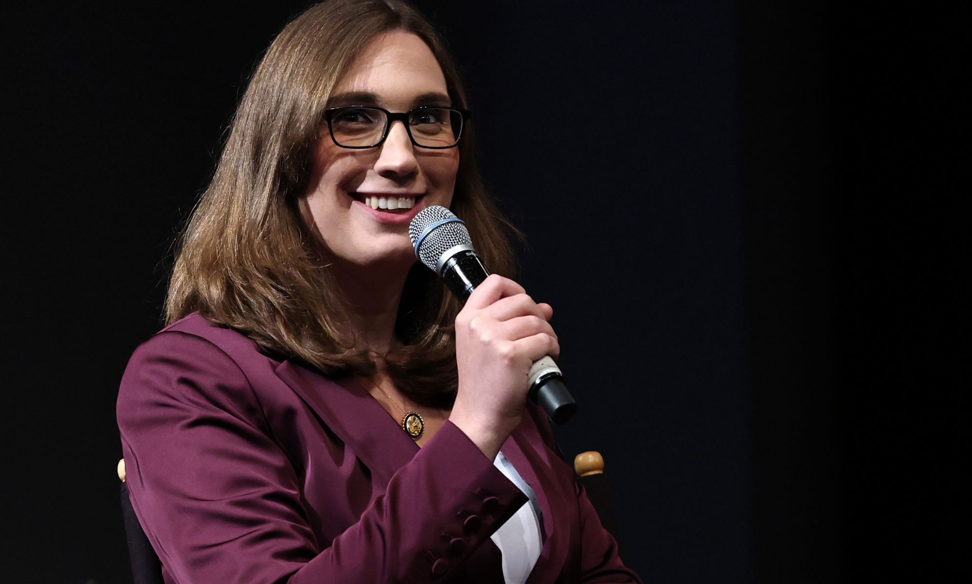 Sarah McBride speaking into a microphone during a panel.