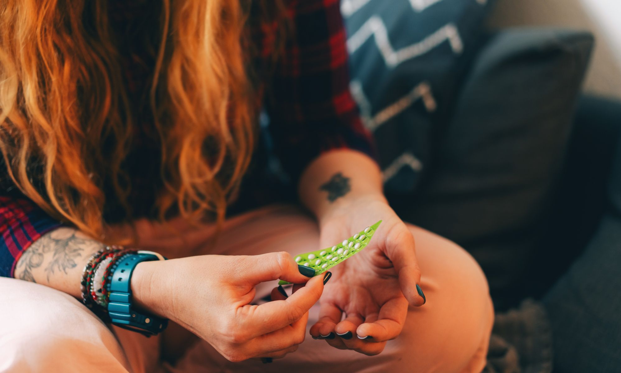 A person sat down taking tablets from a package.