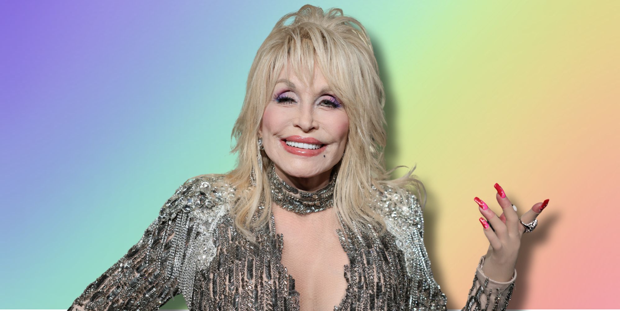 Dolly Parton in a silver outfit smiling, holding her hand in out. She is imposed against a rainbow background.