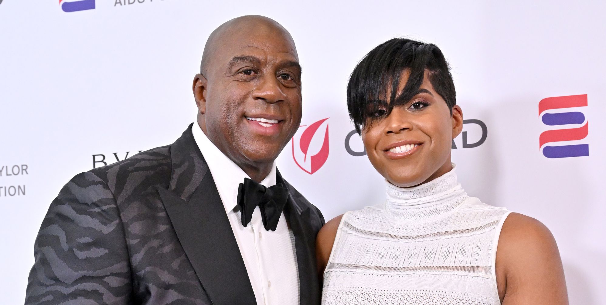 Magic Johnson and his gay son, EJ Johnson smile on a red carpet together.