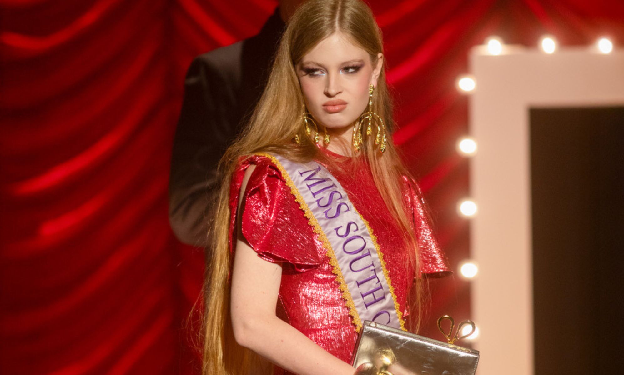 Vivian Jenna Wilson in a red gown and sash for Alexis Bittar