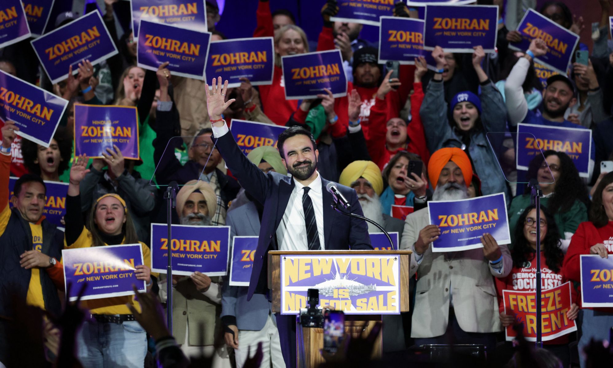 Zohran Mamdani in front of a crowd of supporters. 